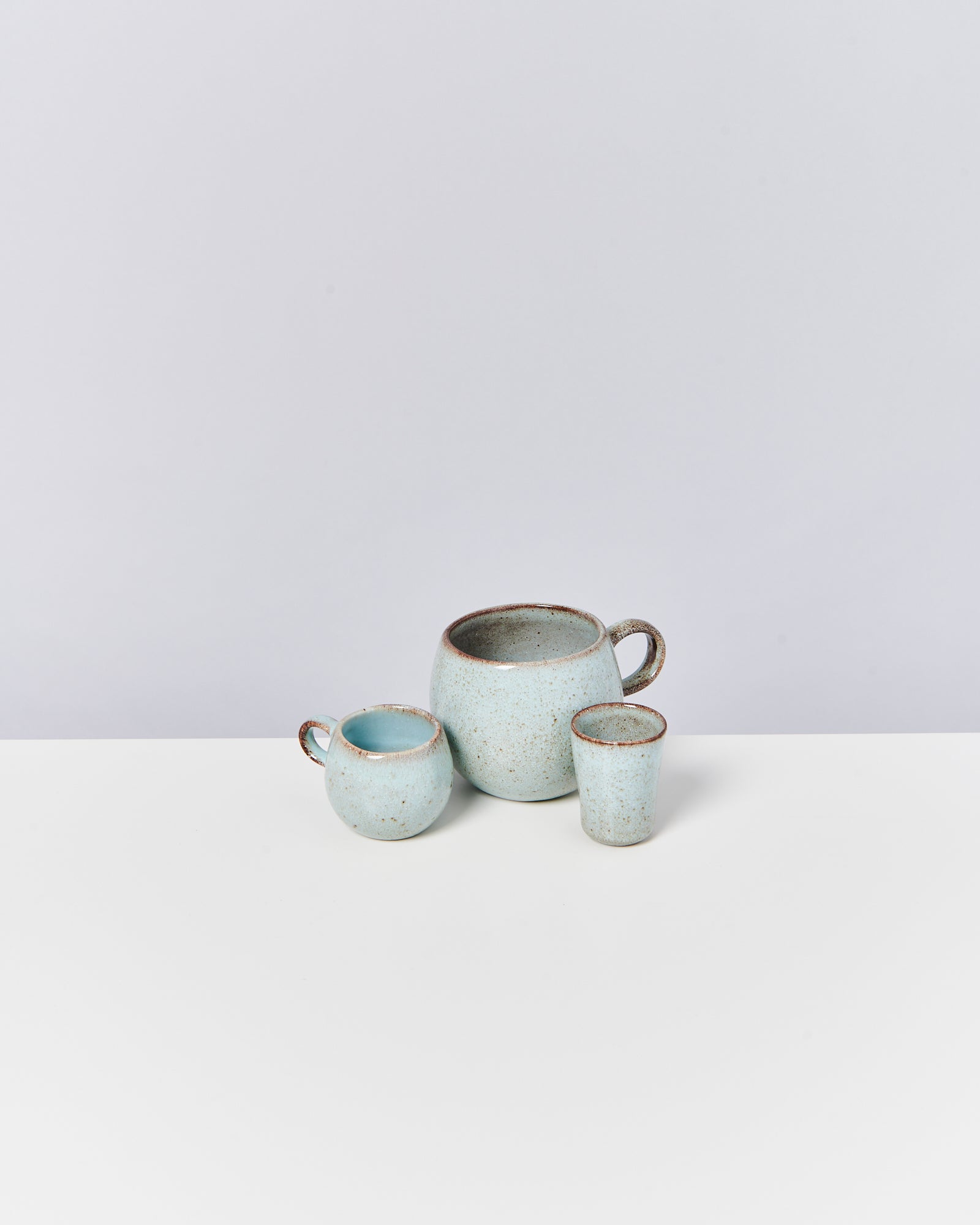 Drei hellblaue Keramikgefäße unterschiedlicher Größe auf weißem Hintergrund.