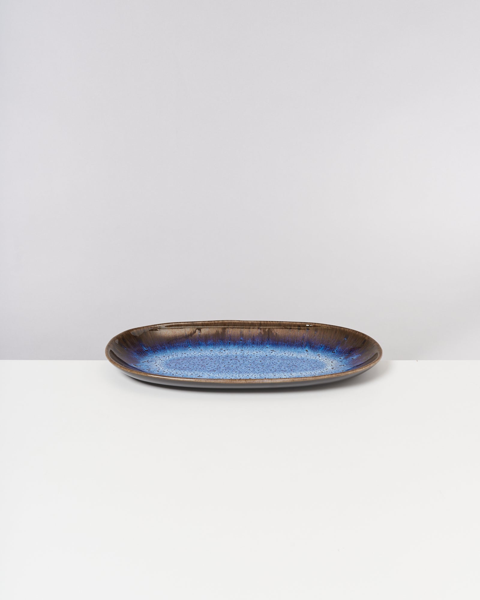 Blauer und brauner Keramikteller auf weißem Hintergrund.