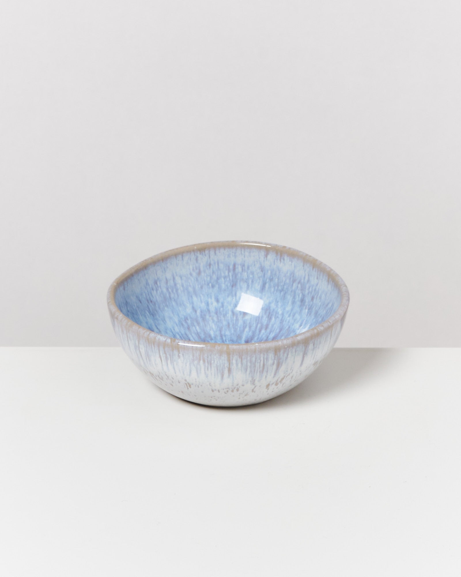 Blaue, glasierte Keramikschale auf einem weißen Hintergrund.