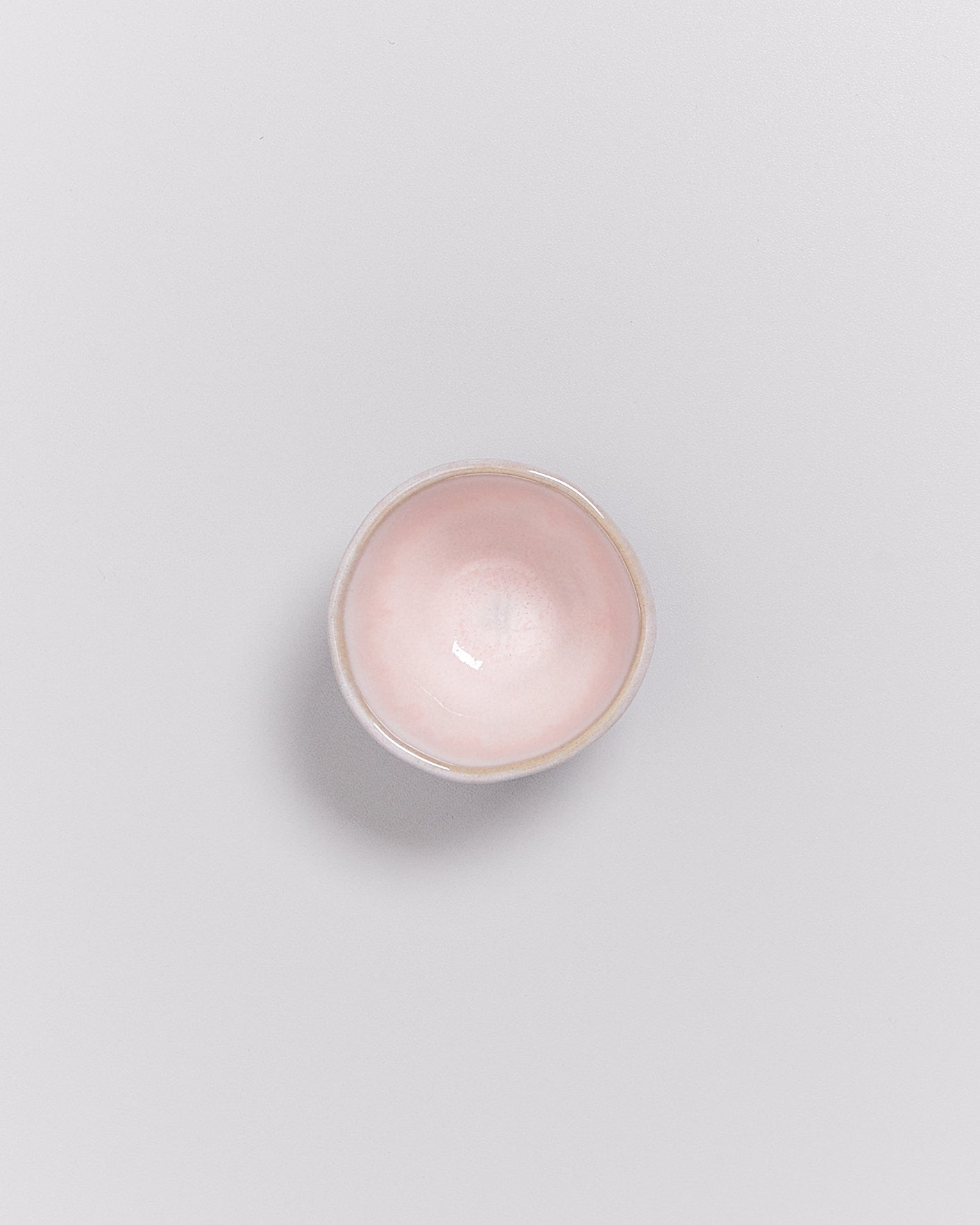 Rosa, runde Keramikschale auf weißem Hintergrund.