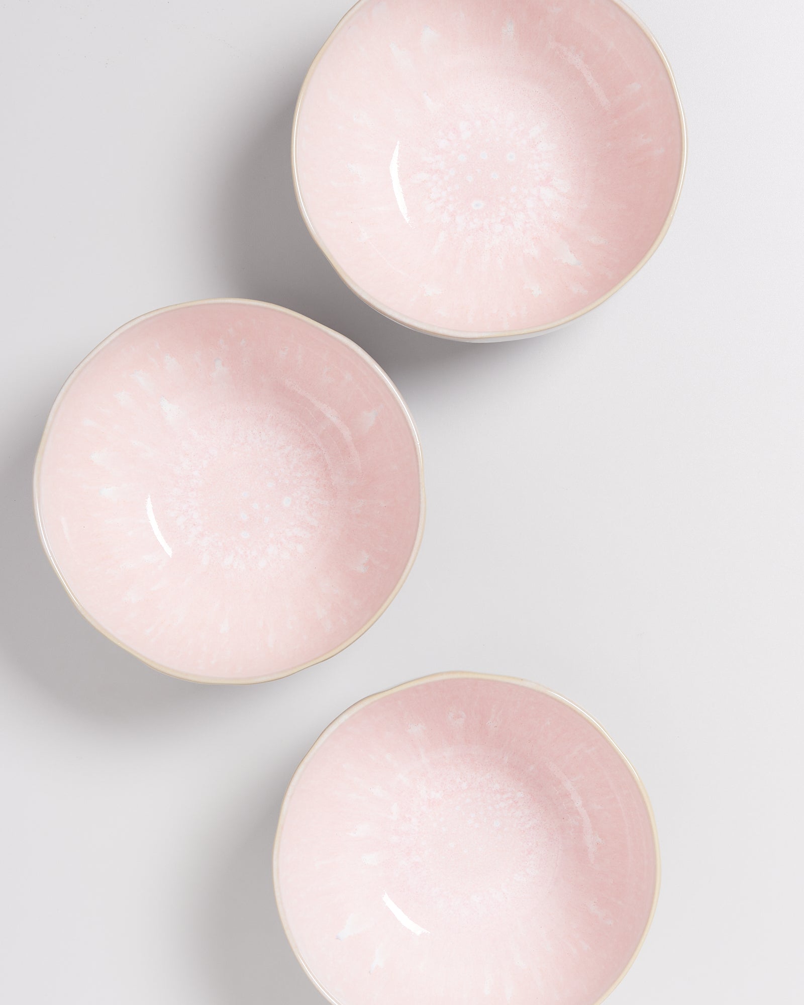 Drei rosa Keramikschalen mit heller Sprenkelmusterung auf weißem Hintergrund.