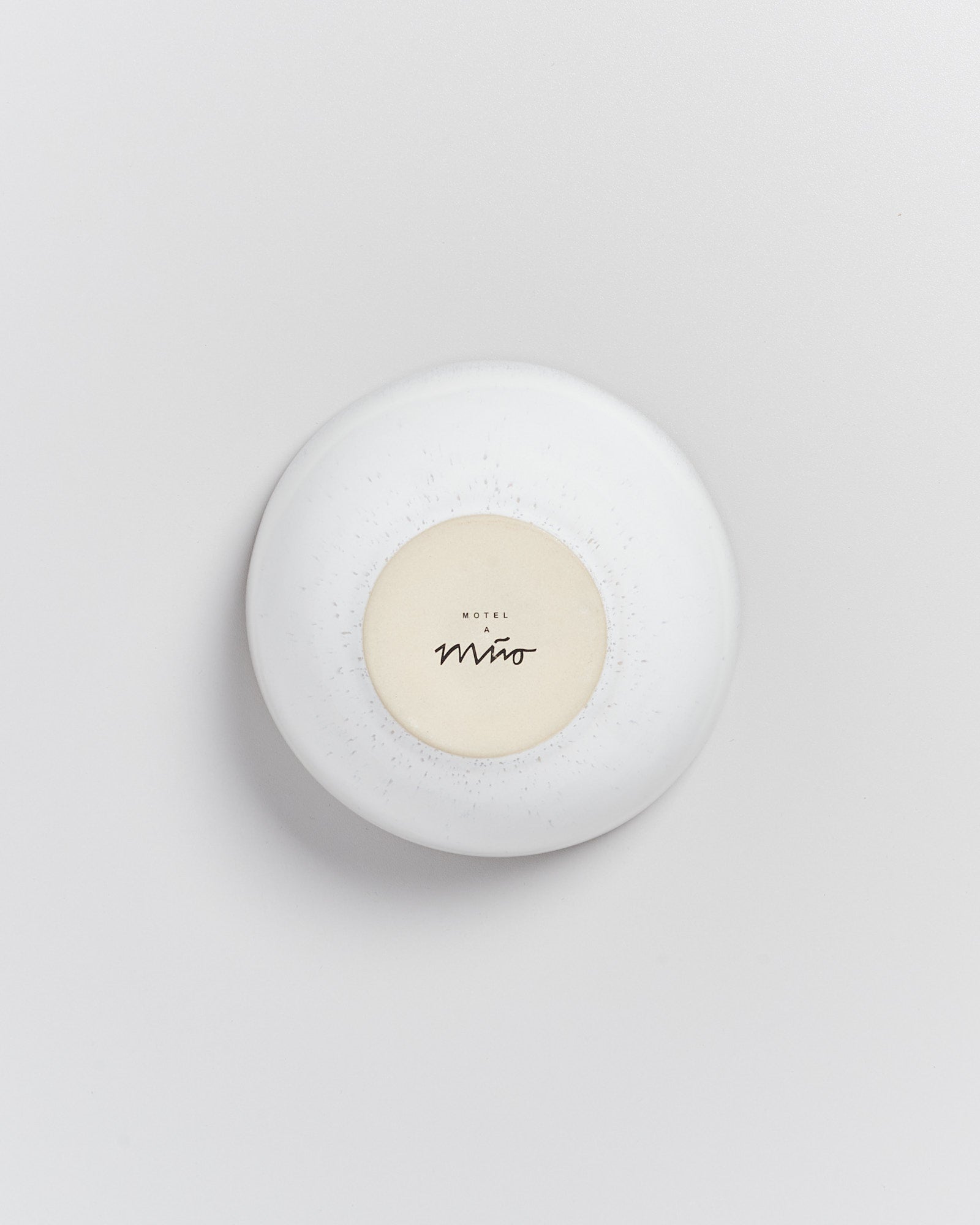Runde Seifenschale auf weißem Hintergrund mit dem Aufdruck "Motel A Miro" in der Mitte.