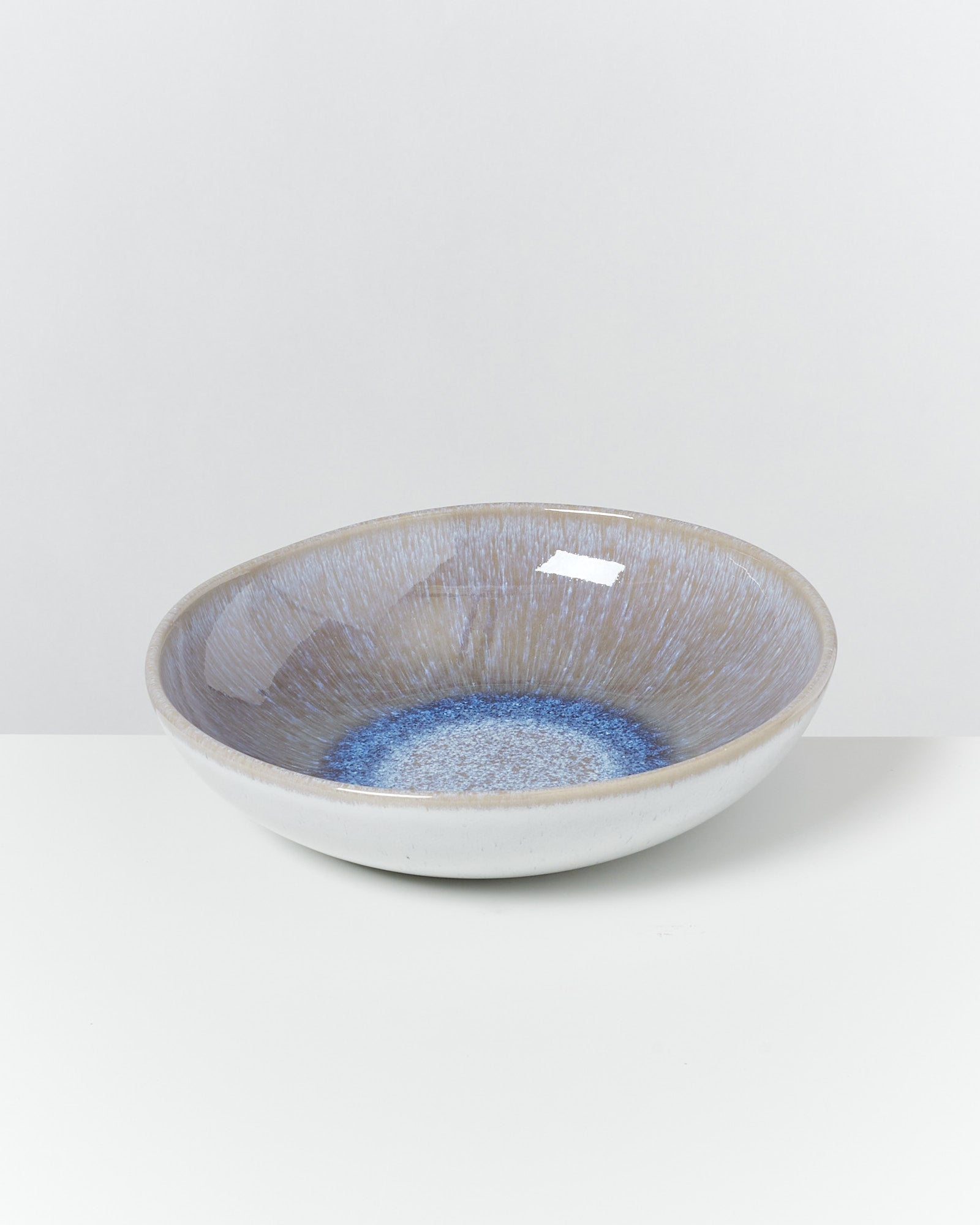 Keramikschale mit blauer und grauer Glasur auf weißem Hintergrund.