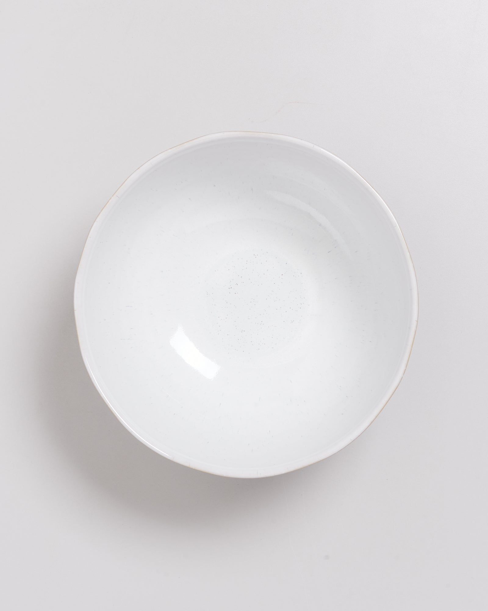 Weiße, runde Schale auf einem hellgrauen Hintergrund.