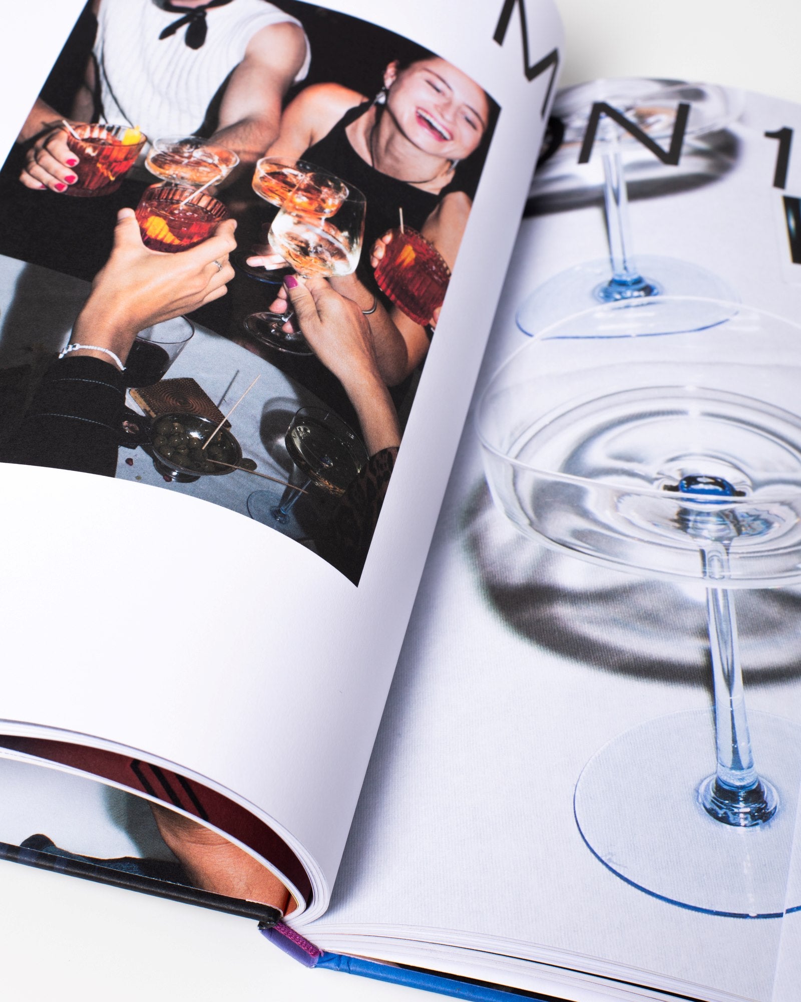 Offenes Buch mit Fotos von lächelnden Menschen und Getränken in Gläsern.