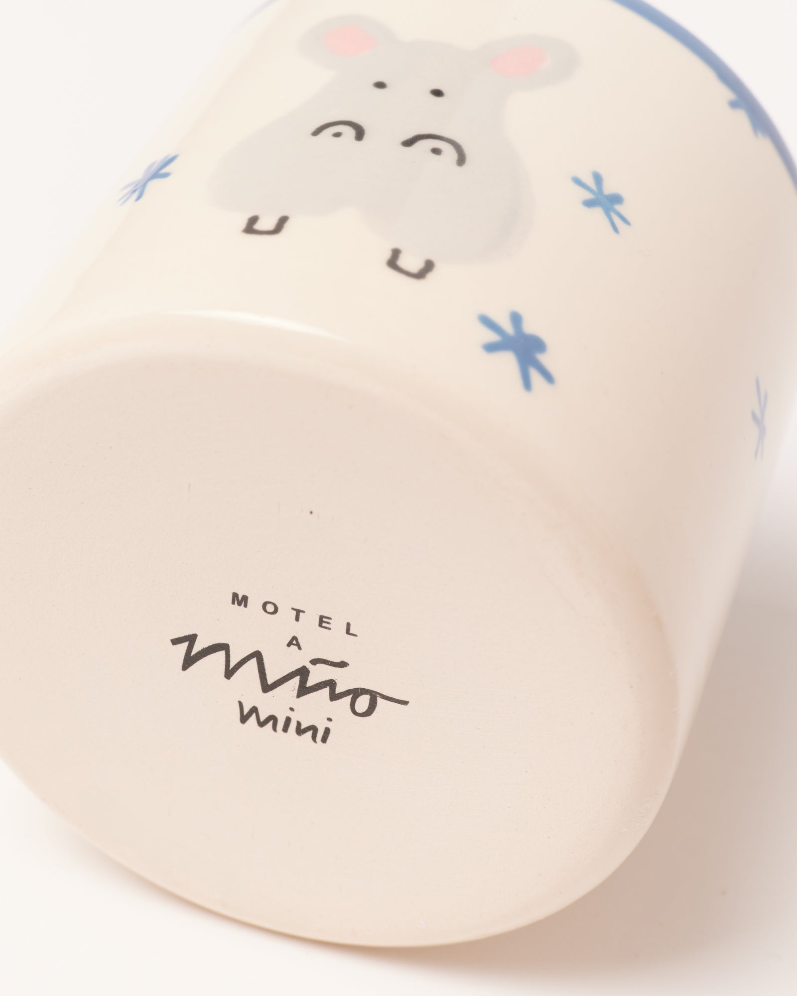 Kaffeebecher mit einem niedlichen Tier-Motiv und blauen Sternen, auf der Unterseite steht „Motel a Miio mini“.