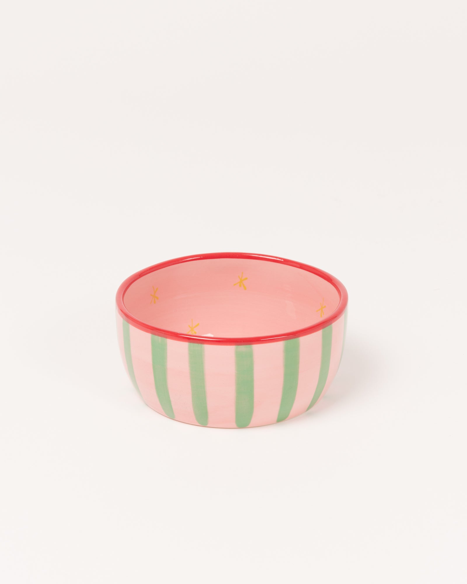 Rosa Schüssel mit grünen Streifen und gelben Sternmotiven, roter Rand.