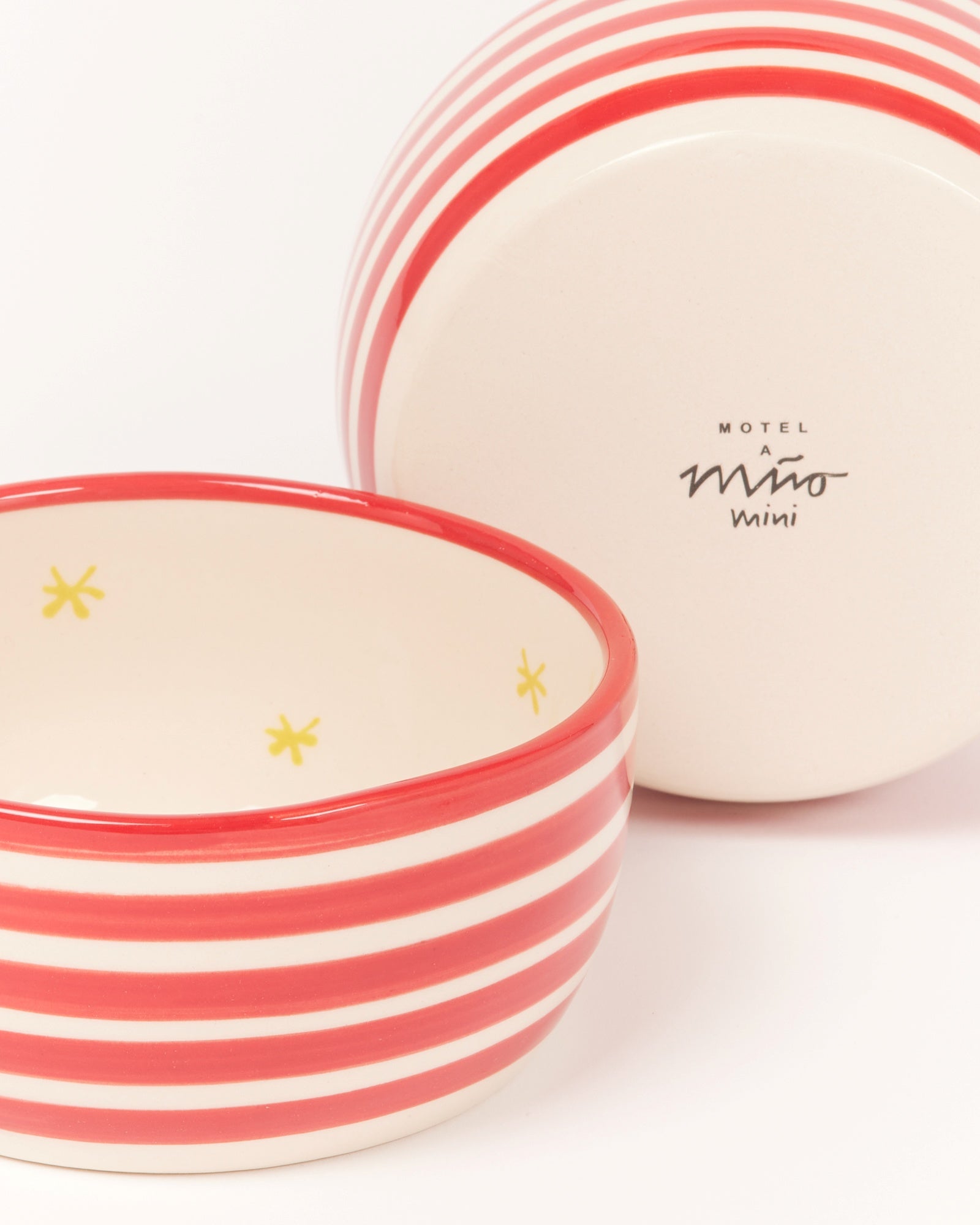 Zwei rot-weiß gestreifte Schüsseln, eine innen mit gelben Sternen und eine mit Schriftzug auf der Unterseite.