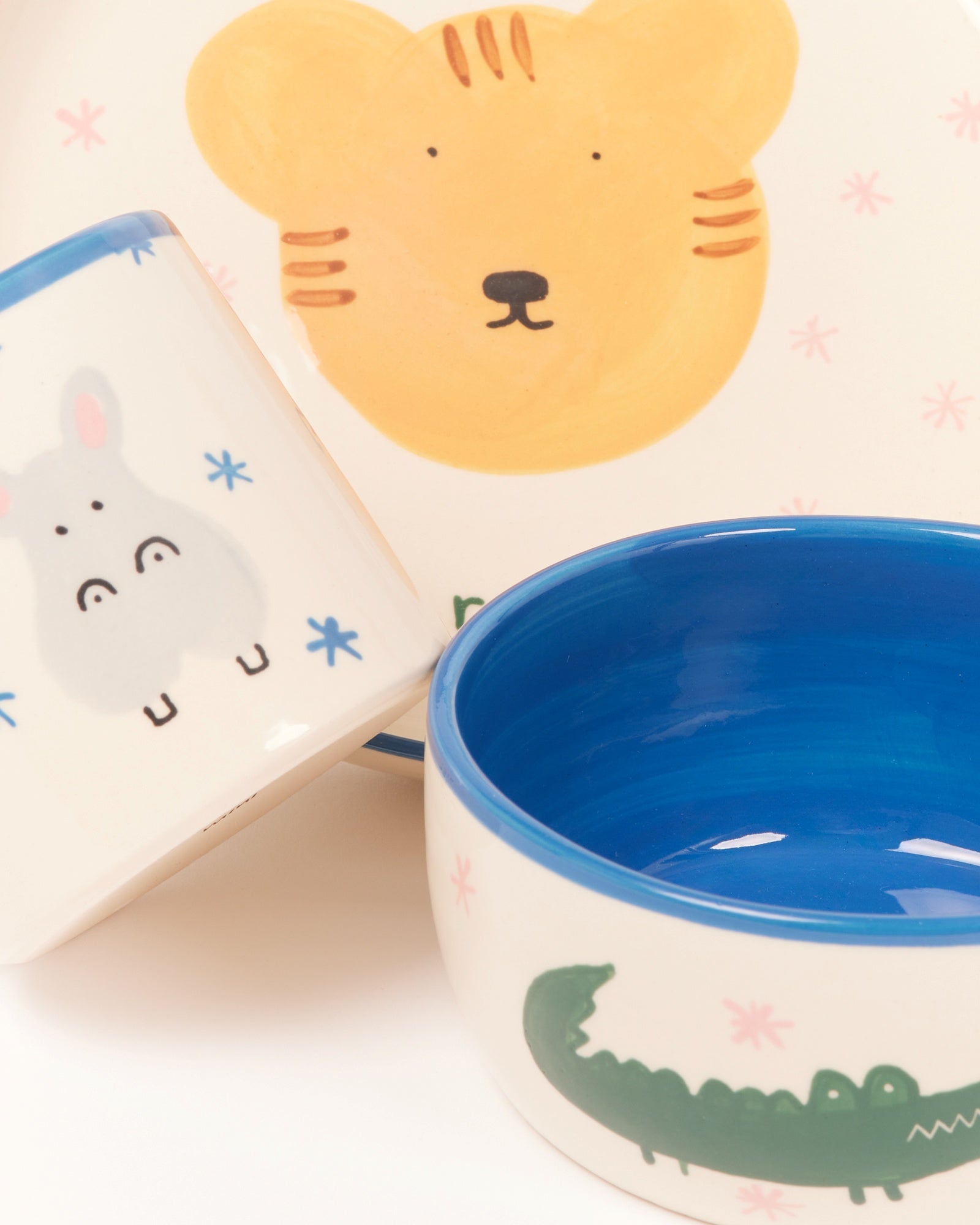 Keramikgeschirr mit bunten Tiermotiven: ein Tiger, ein Nilpferd und ein Krokodil, mit blauem Innenrand.