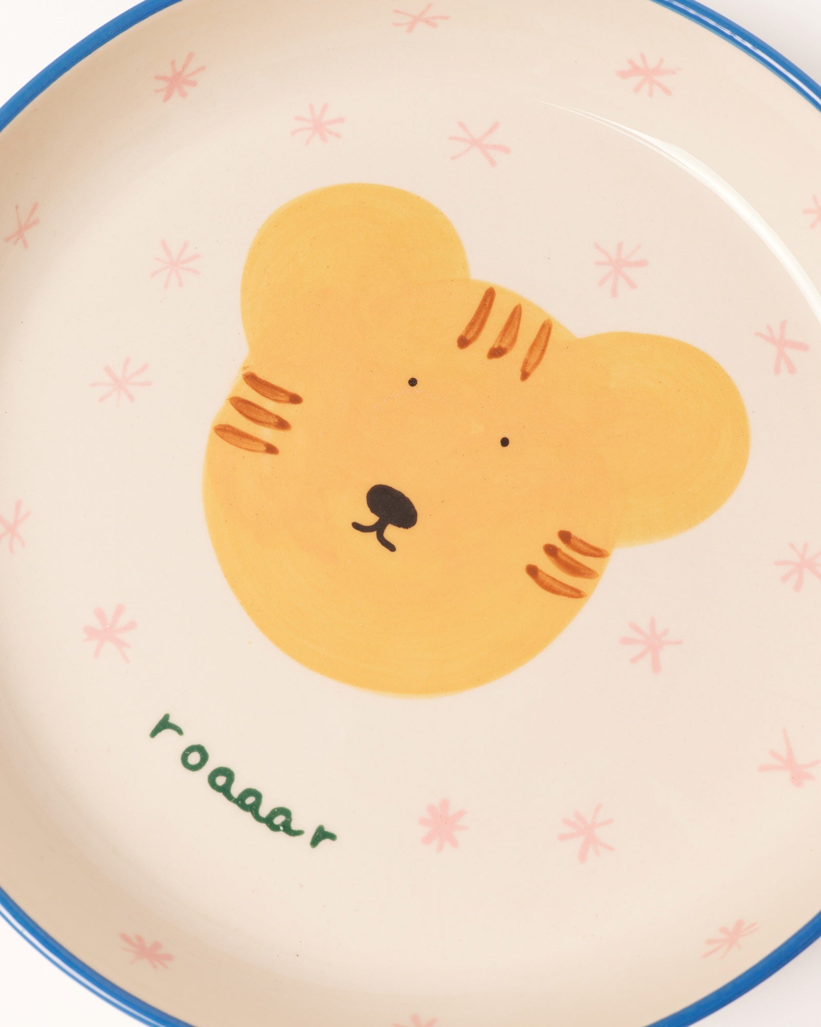 Keramikteller mit einem niedlichen Tigerkopf-Design, umgeben von rosa Sternen und dem Wort "roaaar" darunter.
