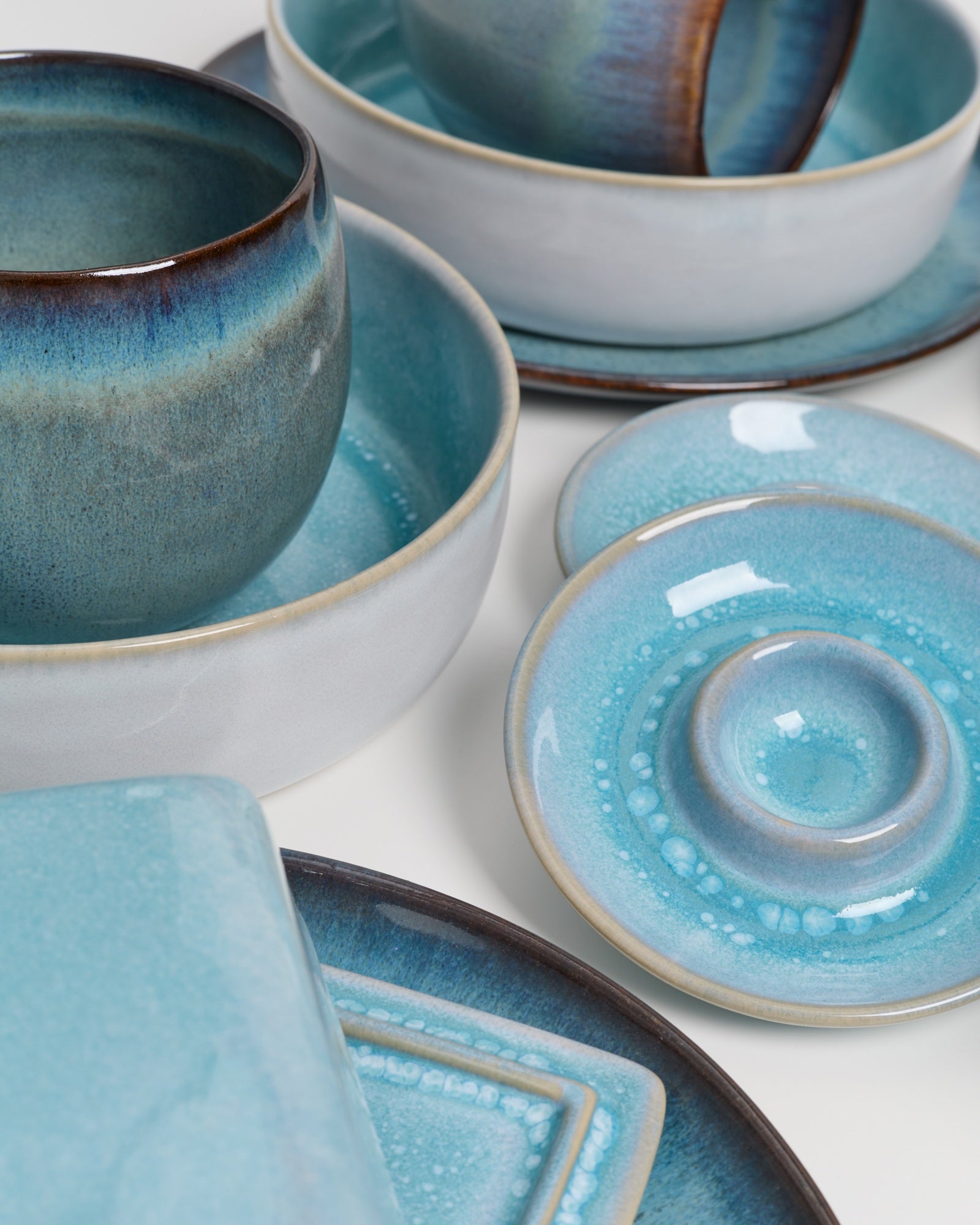 Blaues und graues Keramikgeschirr mit Schalen und Tellern in einem eleganten, modernen Design.