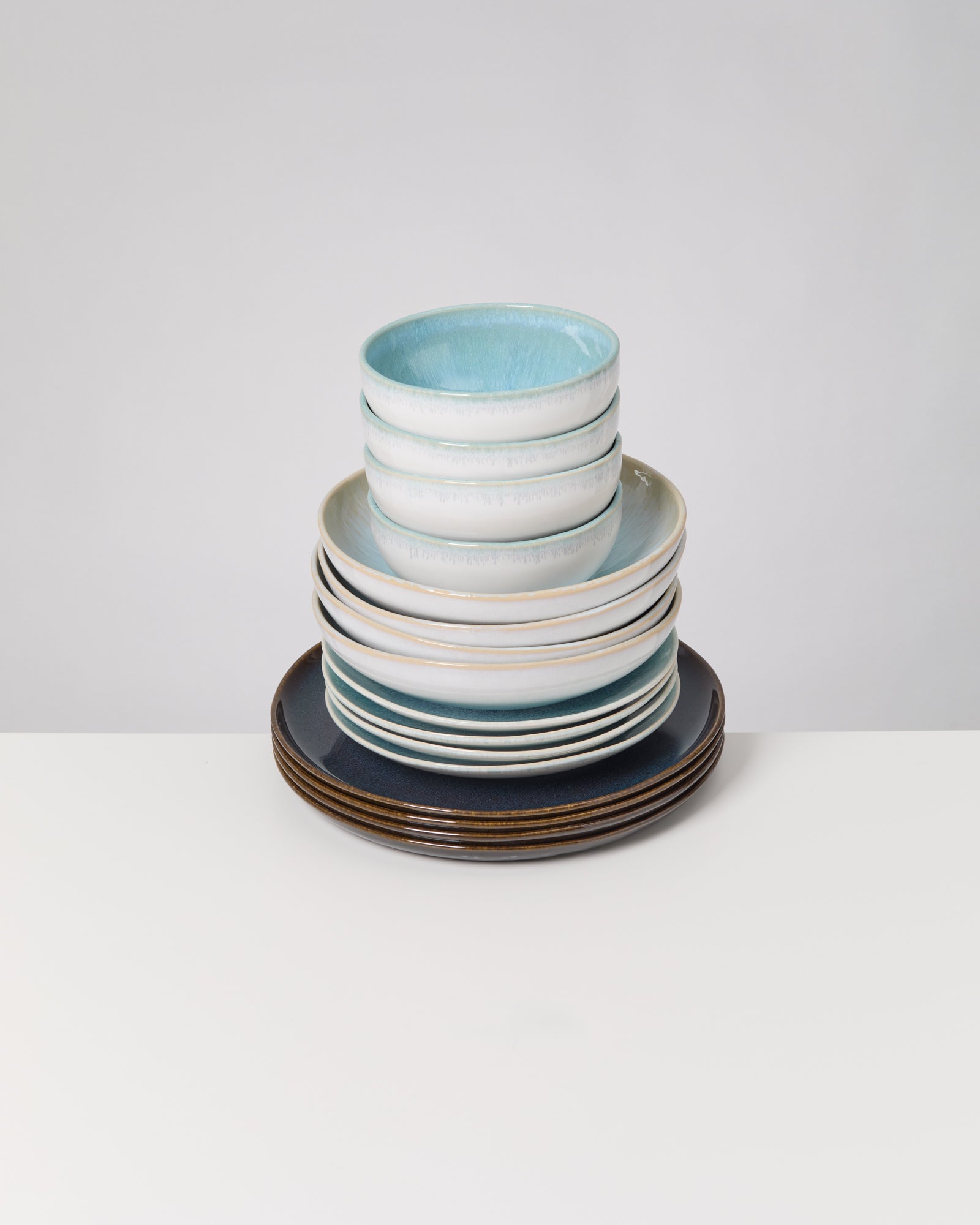 Ein Stapel aus blau-weißen Schalen und Tellern auf einem weißen Tisch.