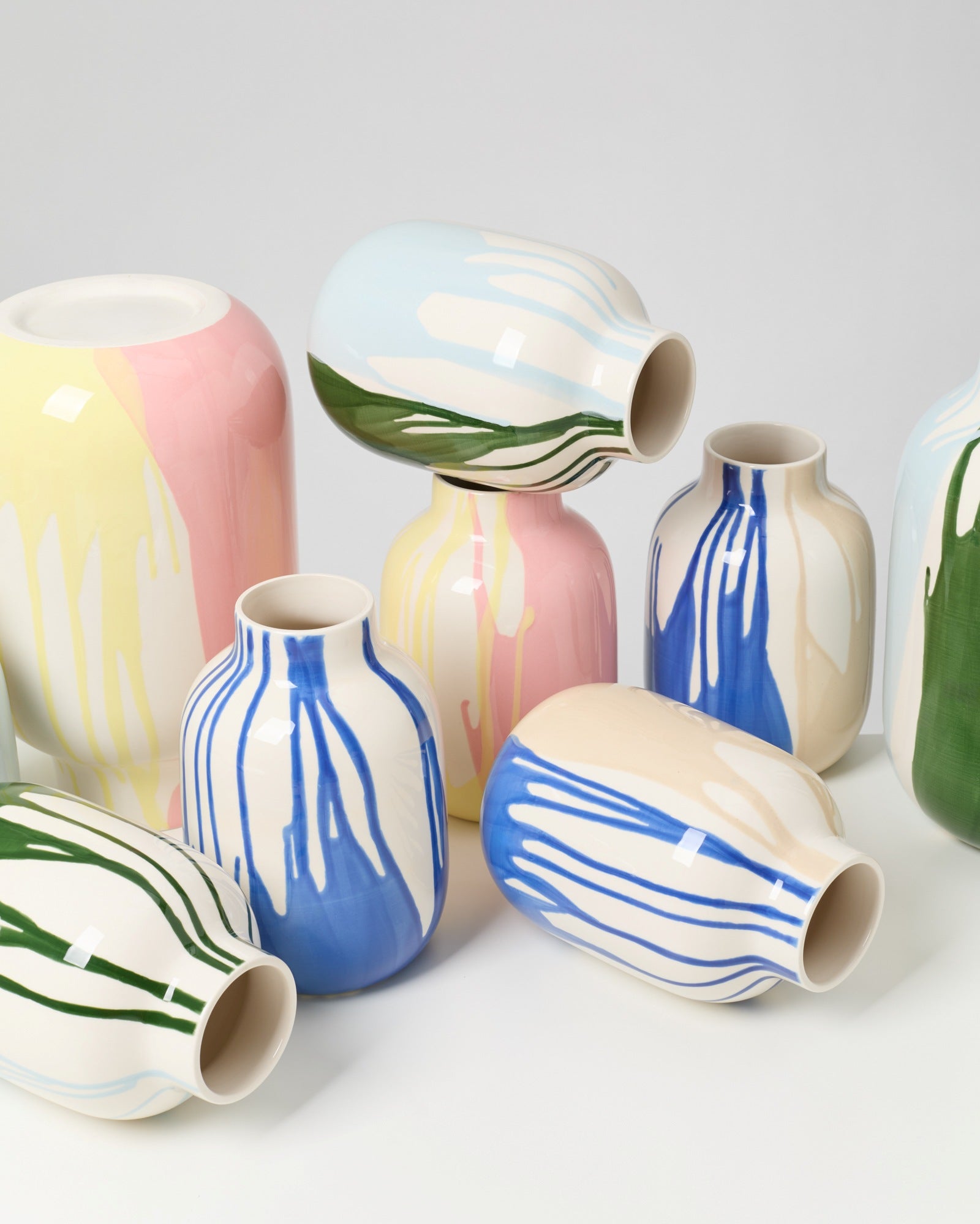 Eine Sammlung von Keramikvasen mit bunten, fließenden Farbmustern in Blau, Grün, Pink und Gelb.