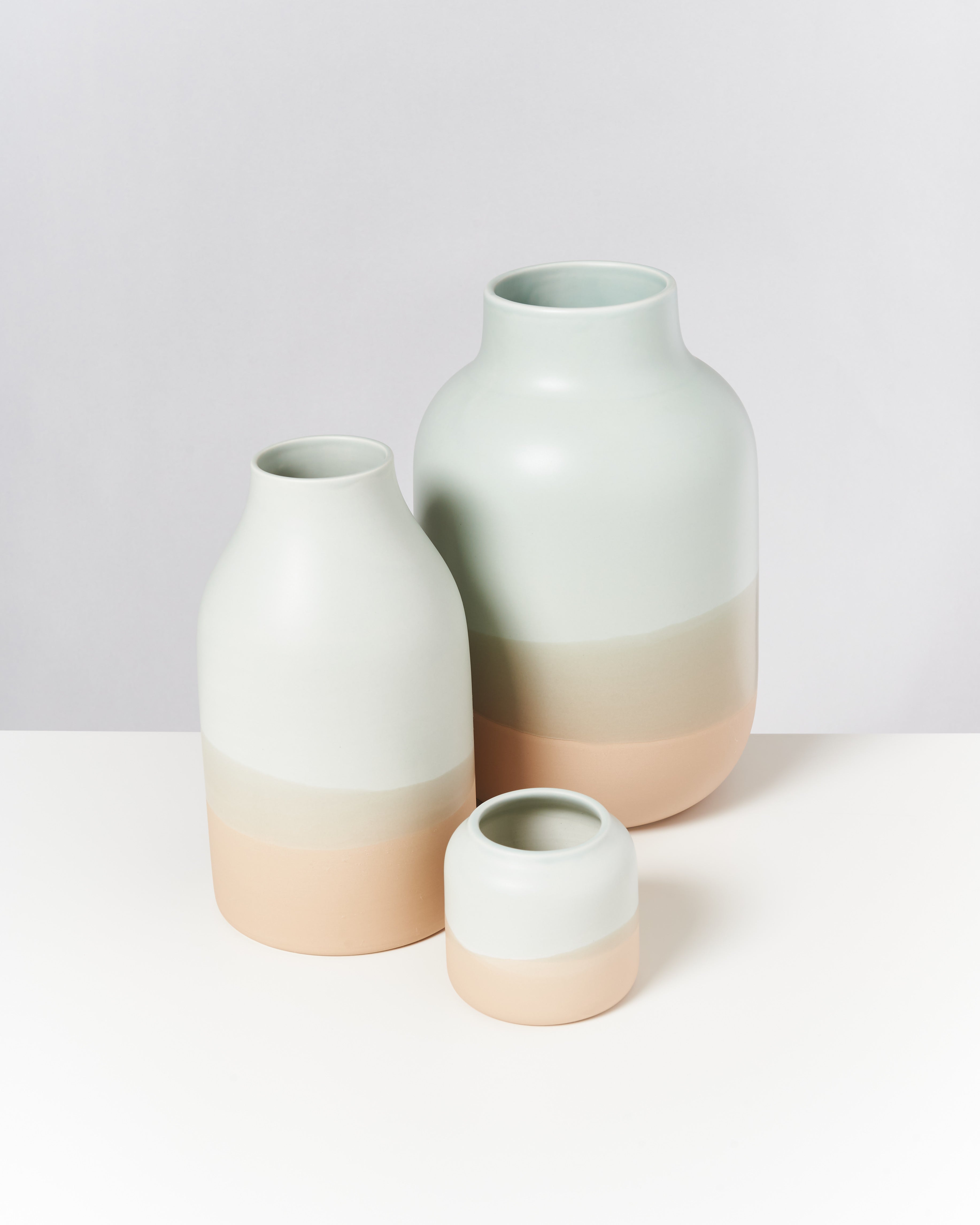 Drei Keramiken in Pastellfarben: zwei große, eine kleine, auf weißem Hintergrund gruppiert.