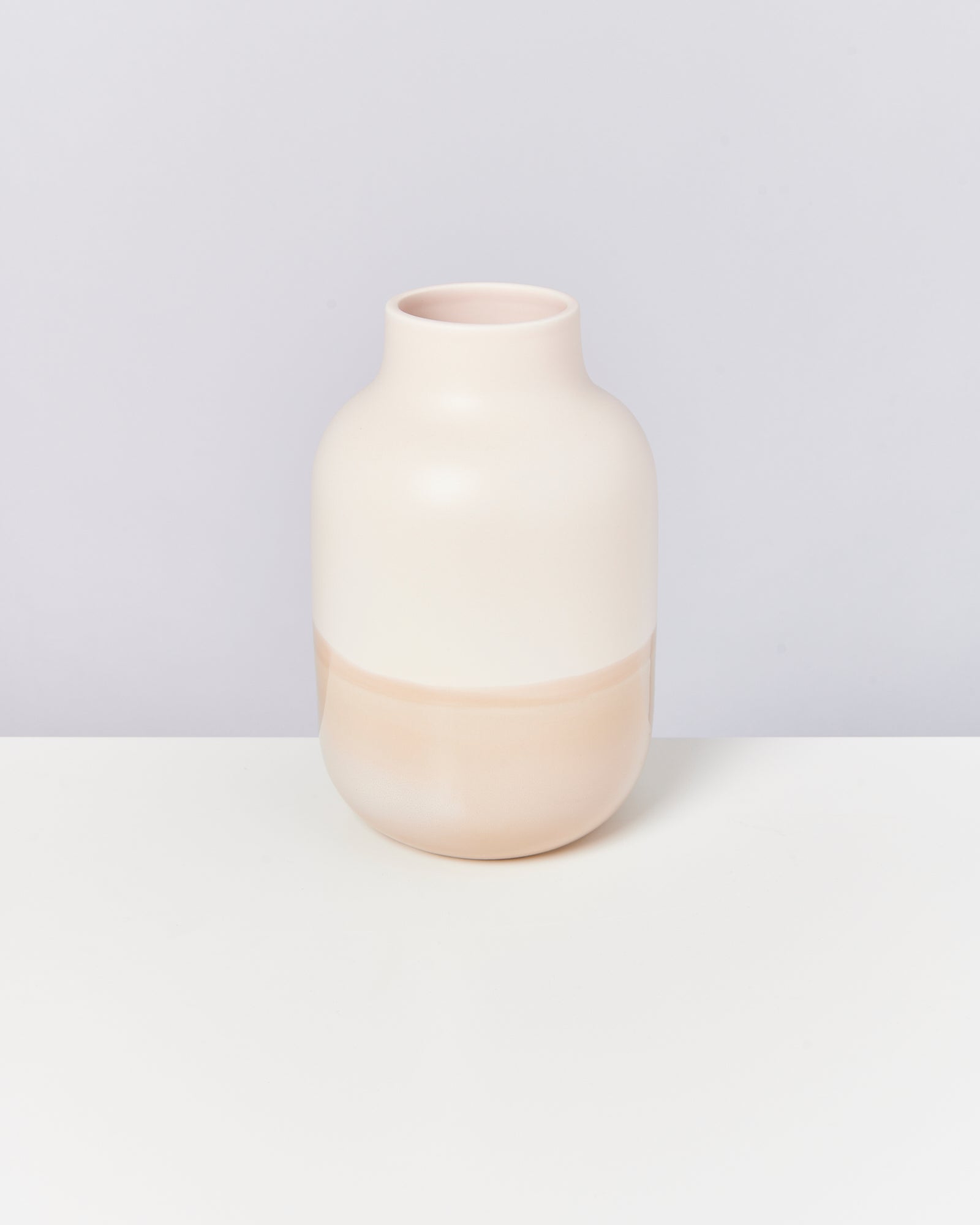 Minimalistische cremefarbene Vase auf weißem Hintergrund.