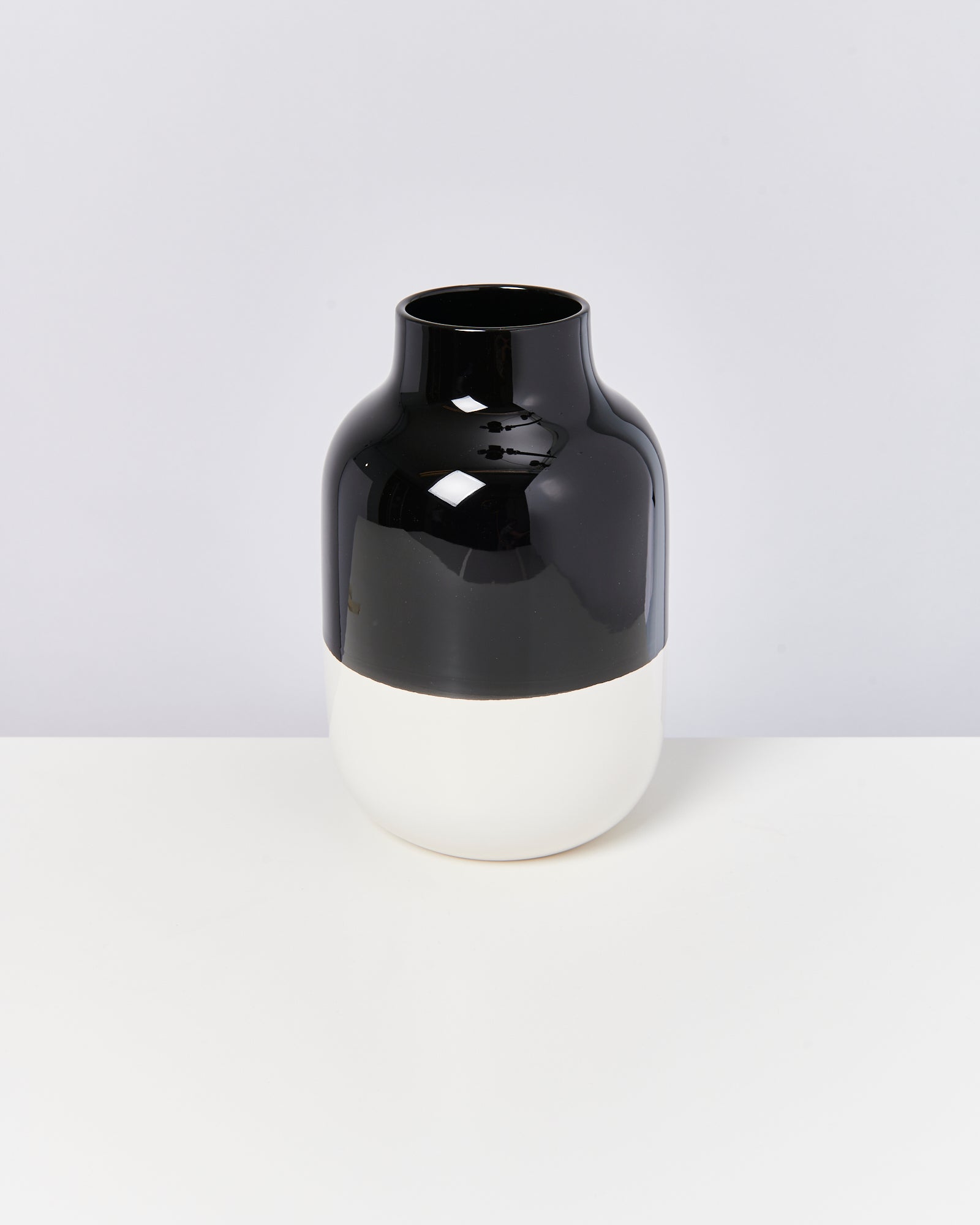 Schwarze und weiße Vase auf einem weißen Hintergrund.