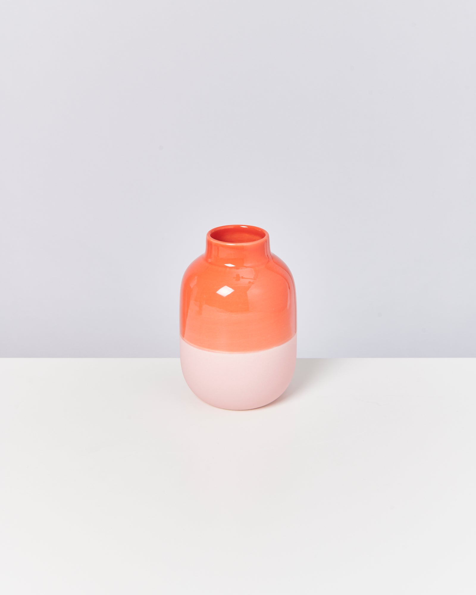 Rot-weiße Keramikvase auf einem weißen Hintergrund.