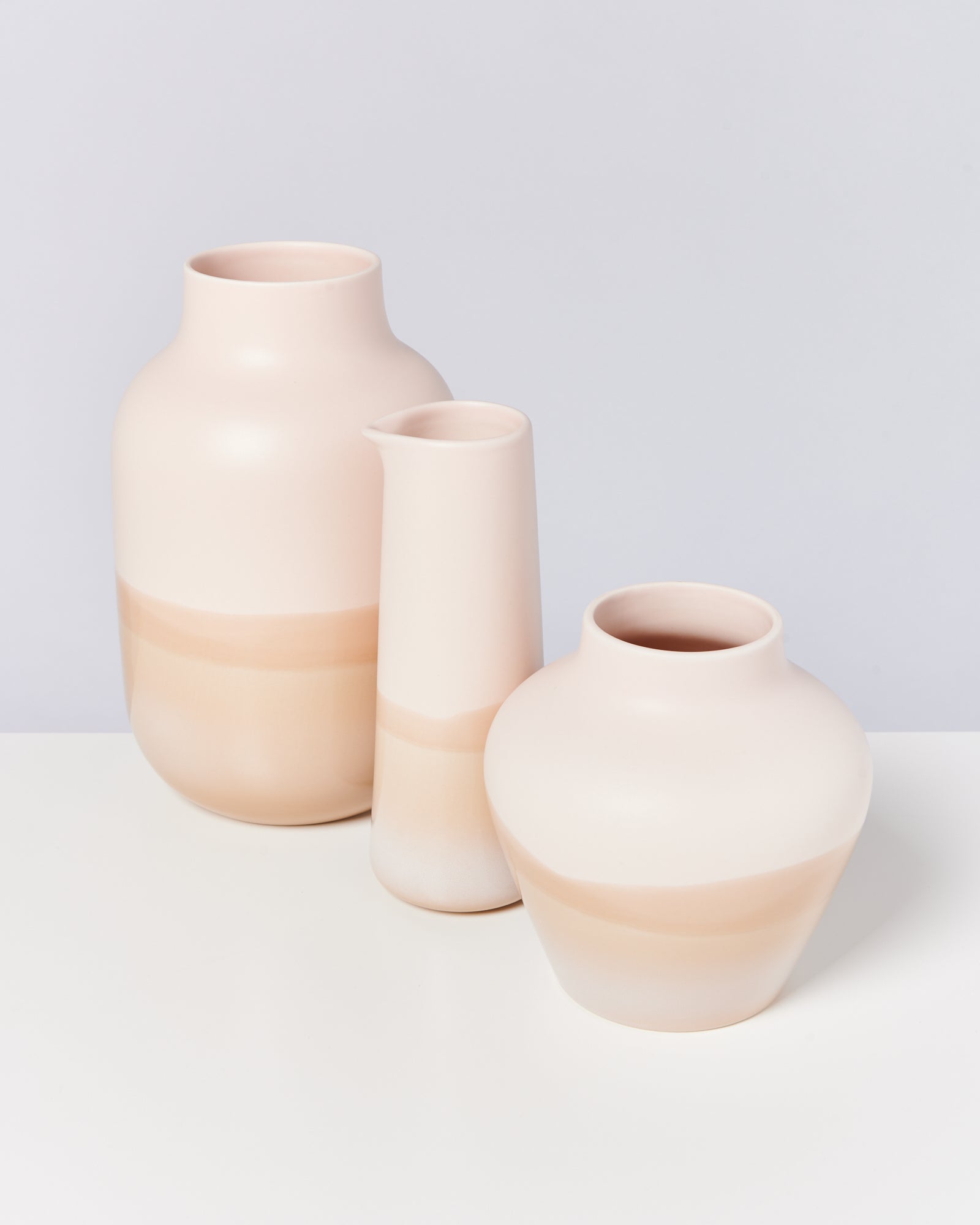 Drei pastellfarbene Vasen in verschiedenen Formen und Größen auf weißem Hintergrund.