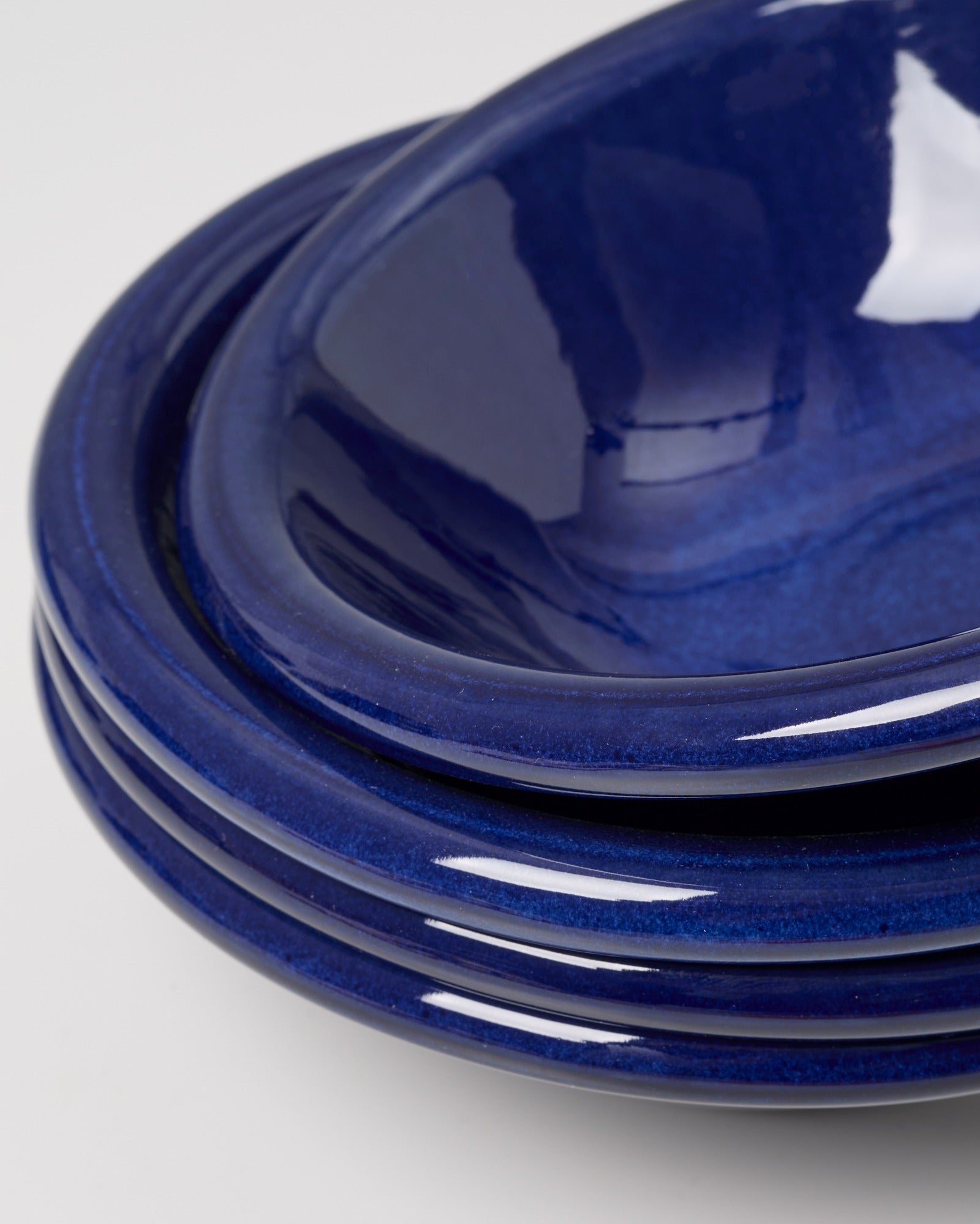 Stapel von blauen Keramiktellern auf einem neutralen Hintergrund.