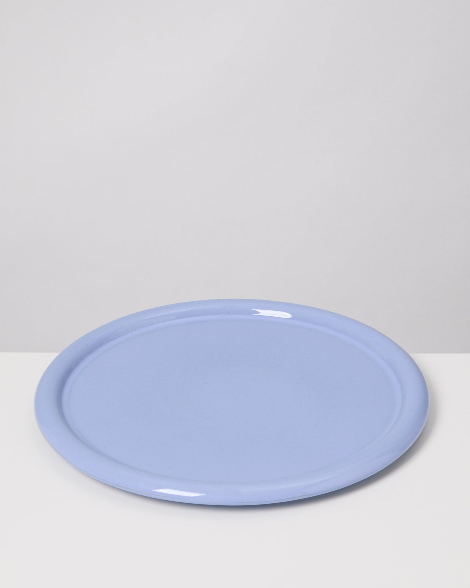 Hellblaue runde Platte auf weißem Hintergrund.