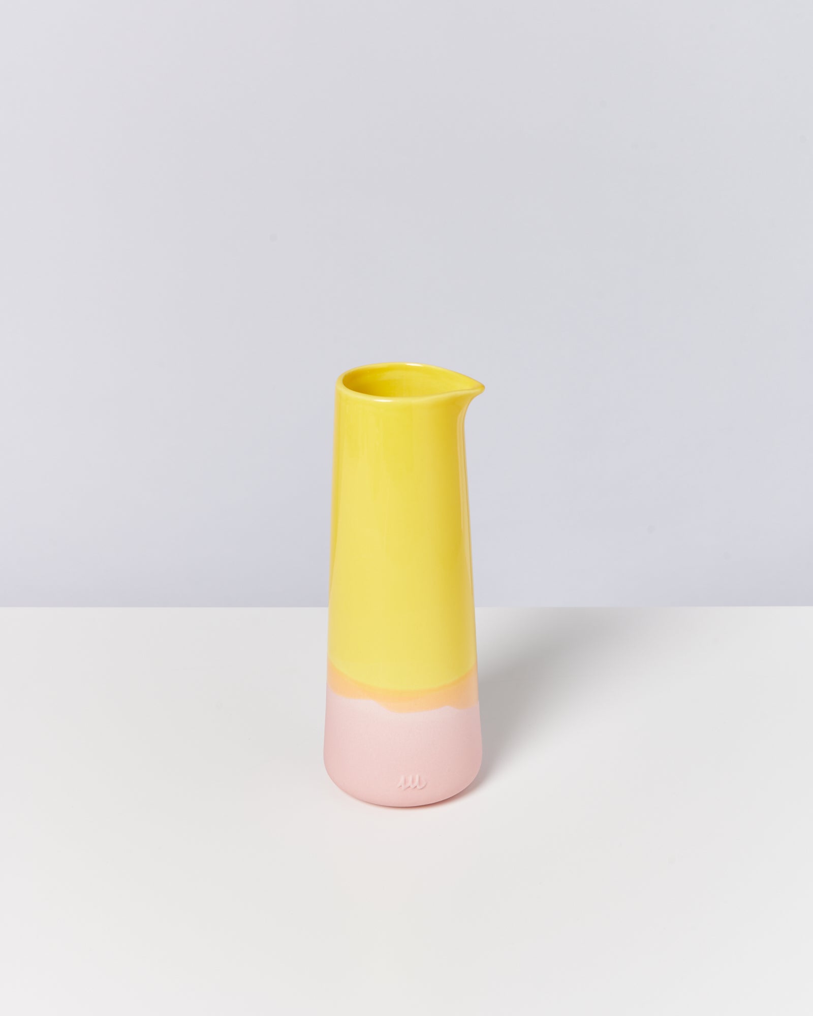 Gelbe und rosa Dose mit Ausgießer auf weißem Hintergrund.