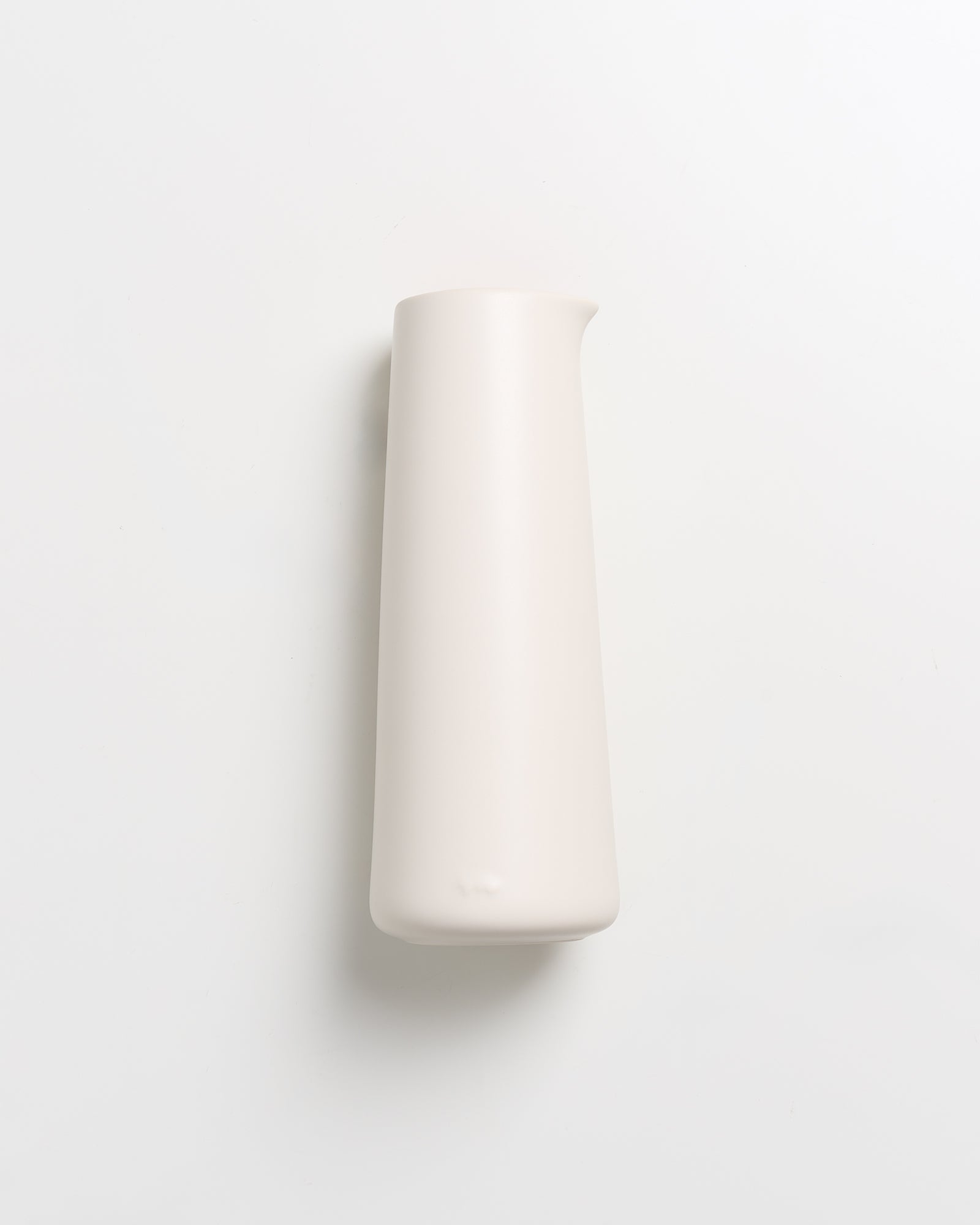 Weiße, schlanke Vase auf weißem Hintergrund.