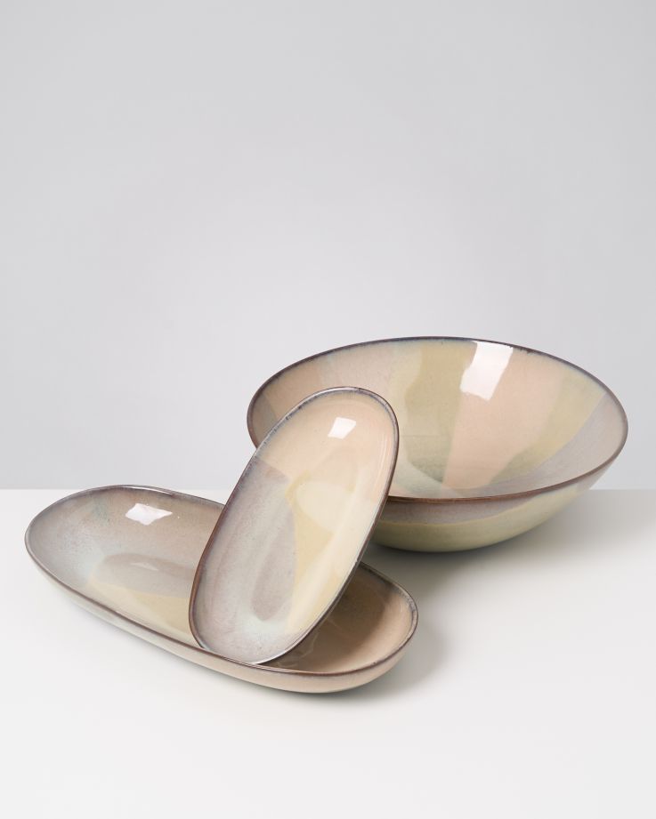 Drei mehrfarbige Keramikschalen auf einem weißen Hintergrund, eine rund und zwei oval.