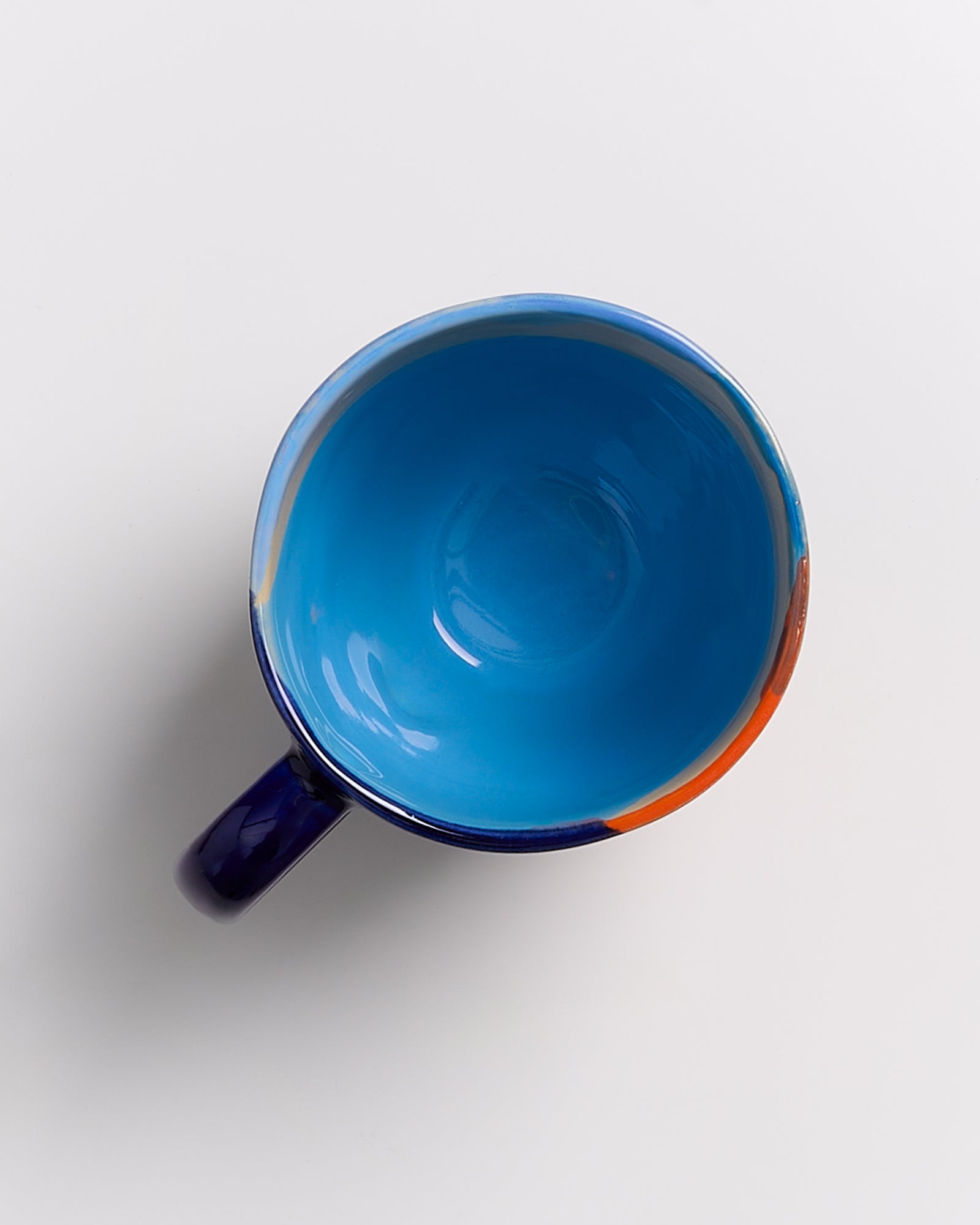Blaue, gefärbte Tasse von oben betrachtet auf hellem Hintergrund.