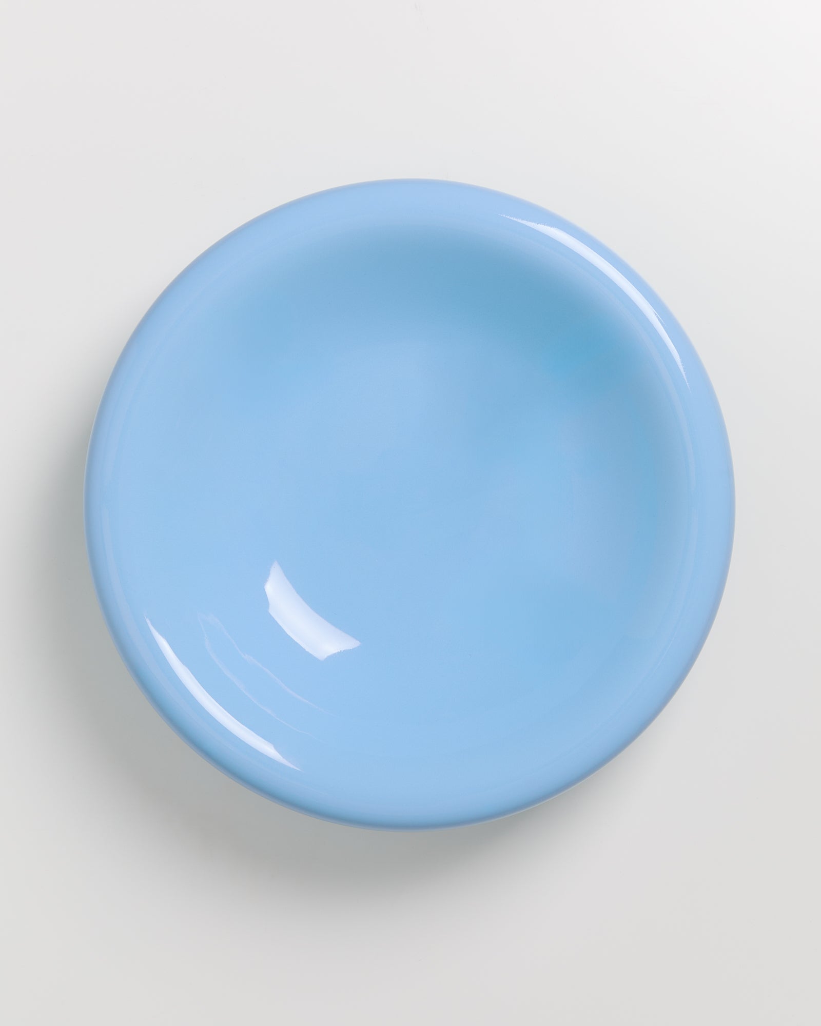 Ein hellblauer, runder Teller auf einem weißen Hintergrund.