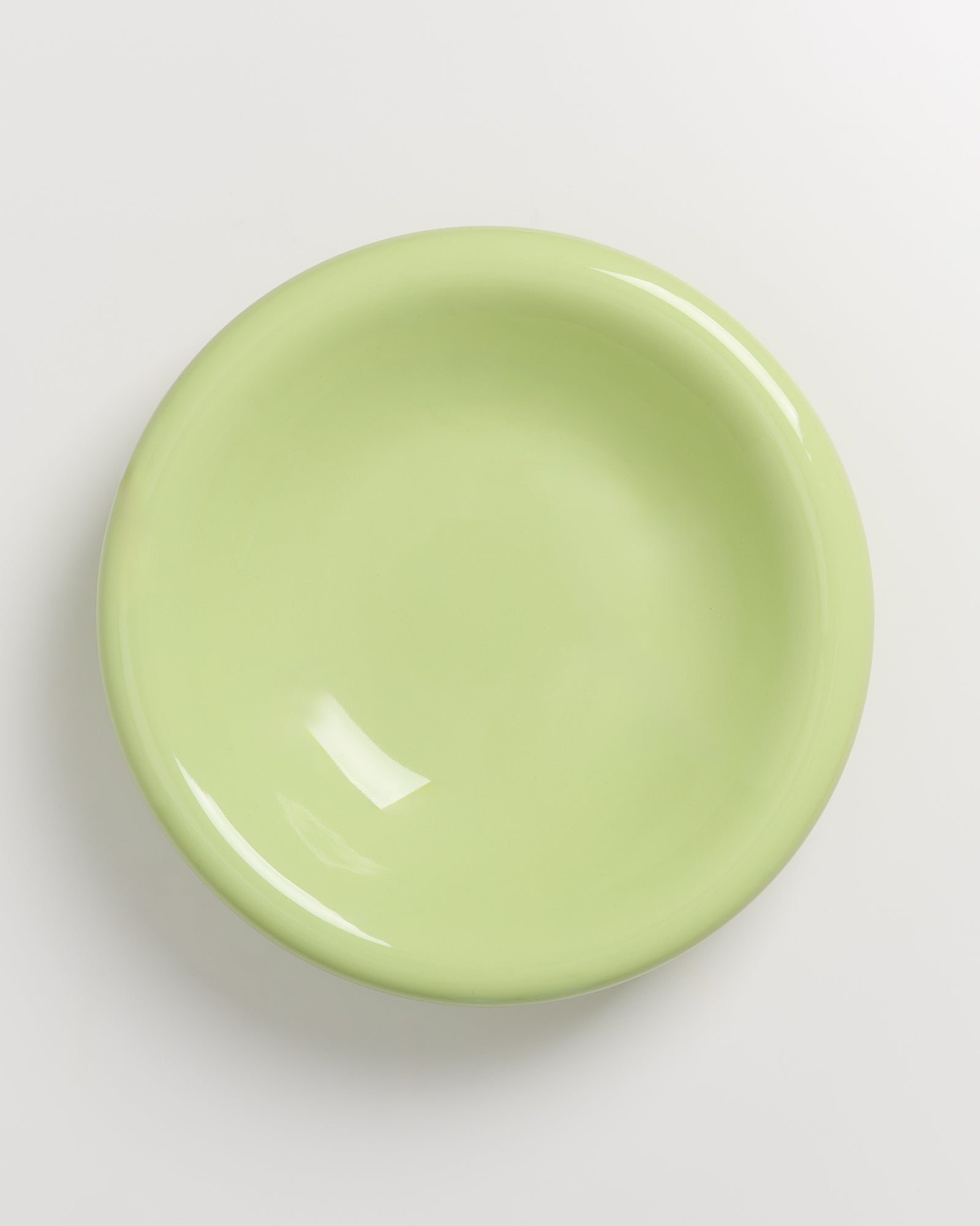 Ein hellgrüner Teller auf einem weißen Hintergrund.