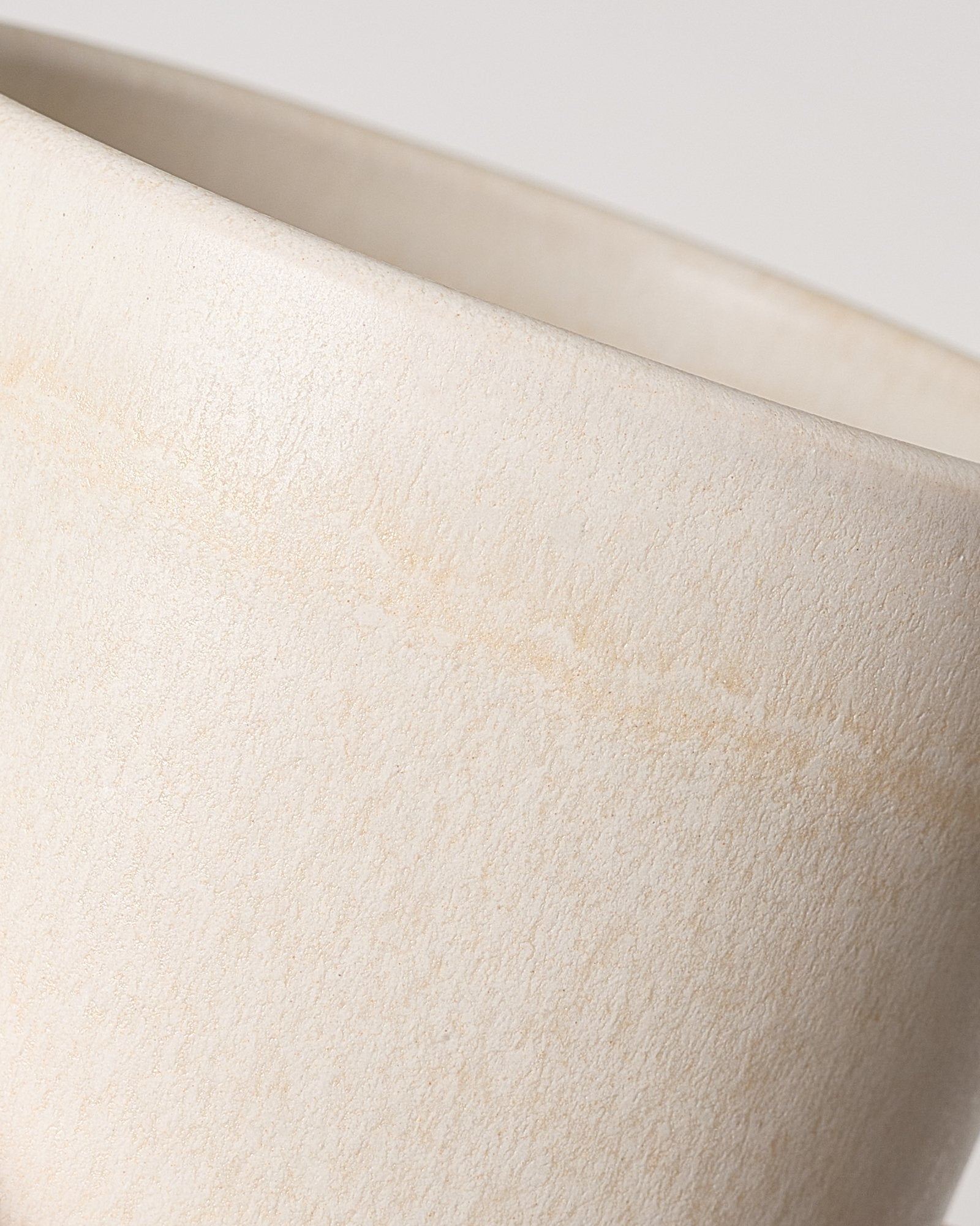 Nahaufnahme einer beigen Keramikschüssel auf weißem Hintergrund.