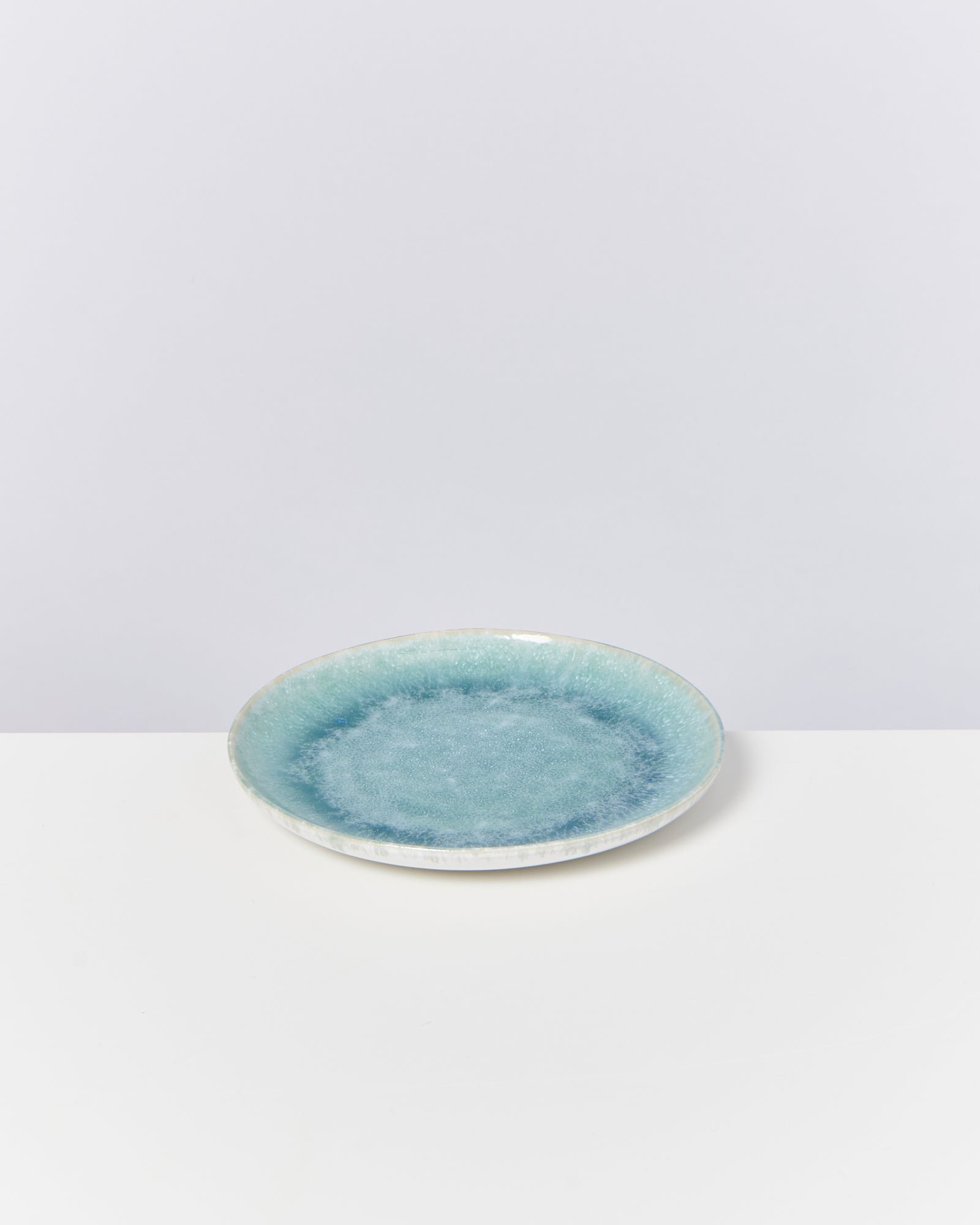 Keramikteller mit blauem Verlauf auf weißem Hintergrund.