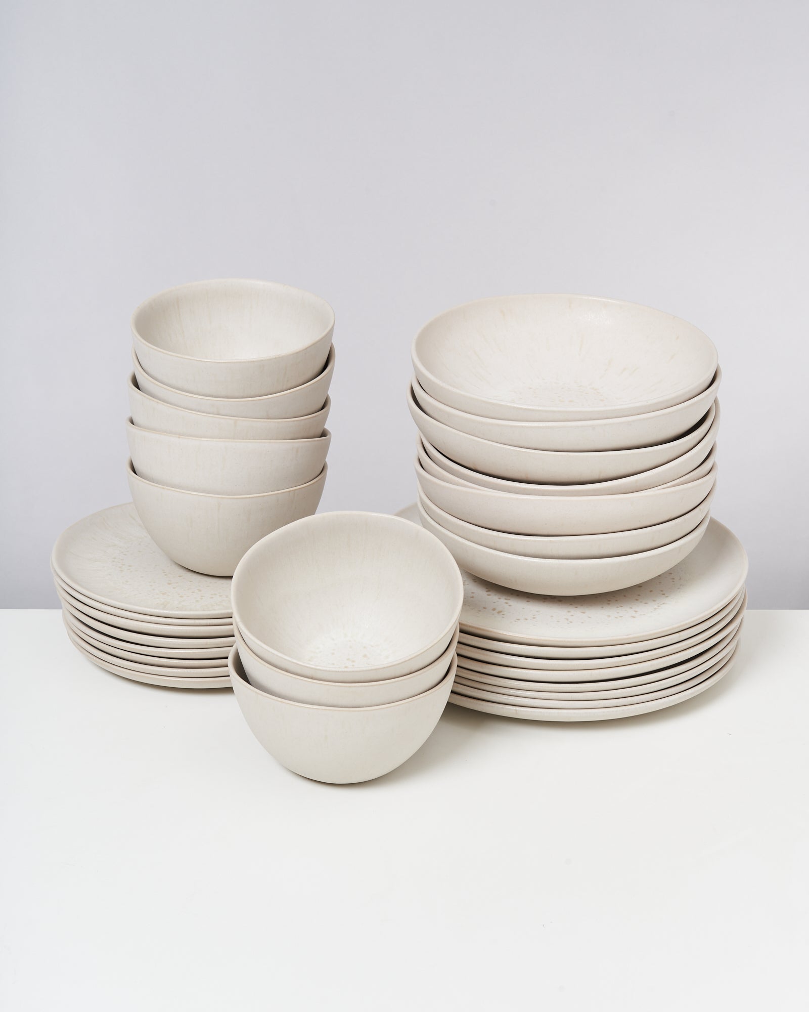 Stapel von weißen Schüsseln und Tellern auf einem Tisch.