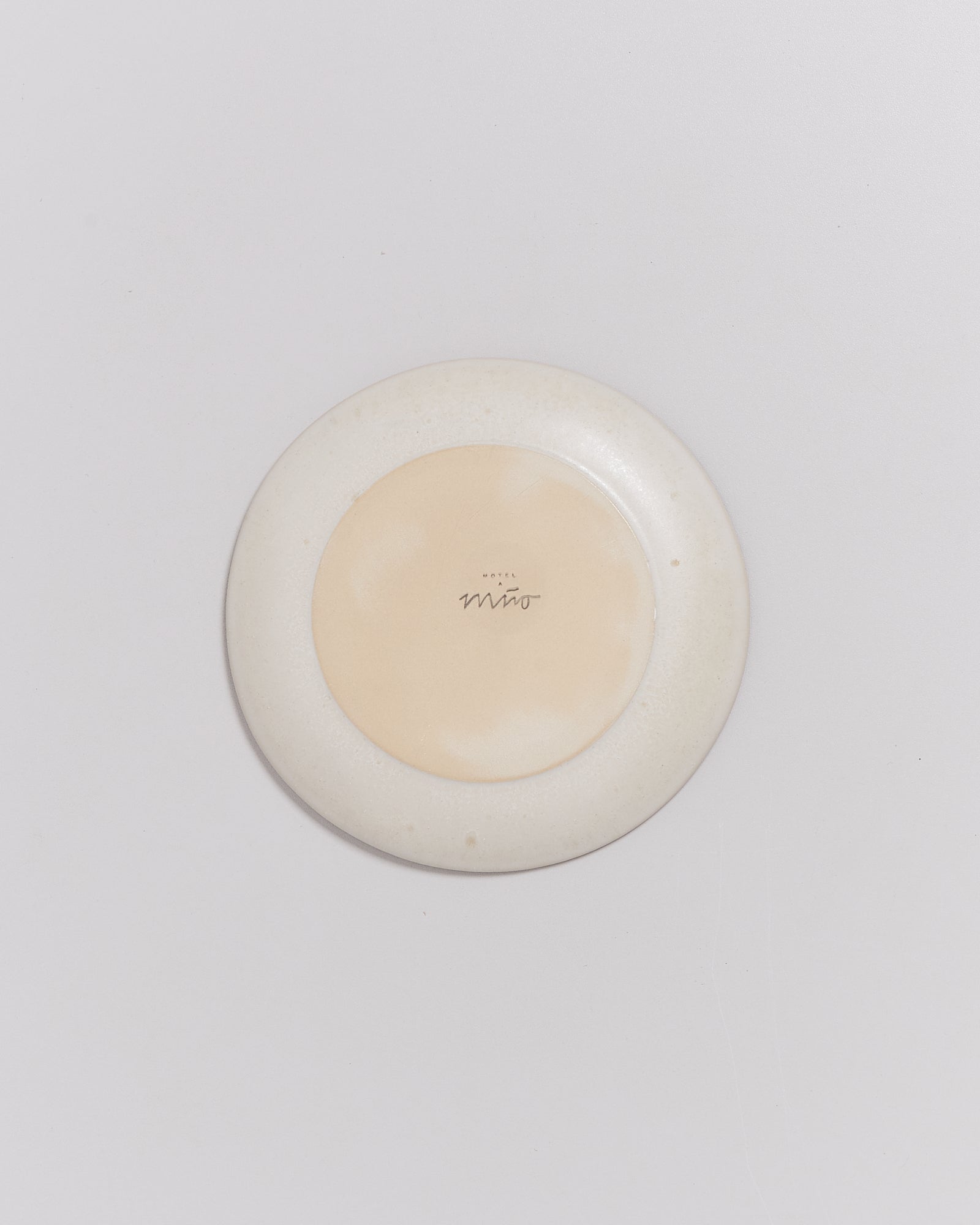 Beige Teller mit Aufschrift in der Mitte auf weißem Hintergrund.