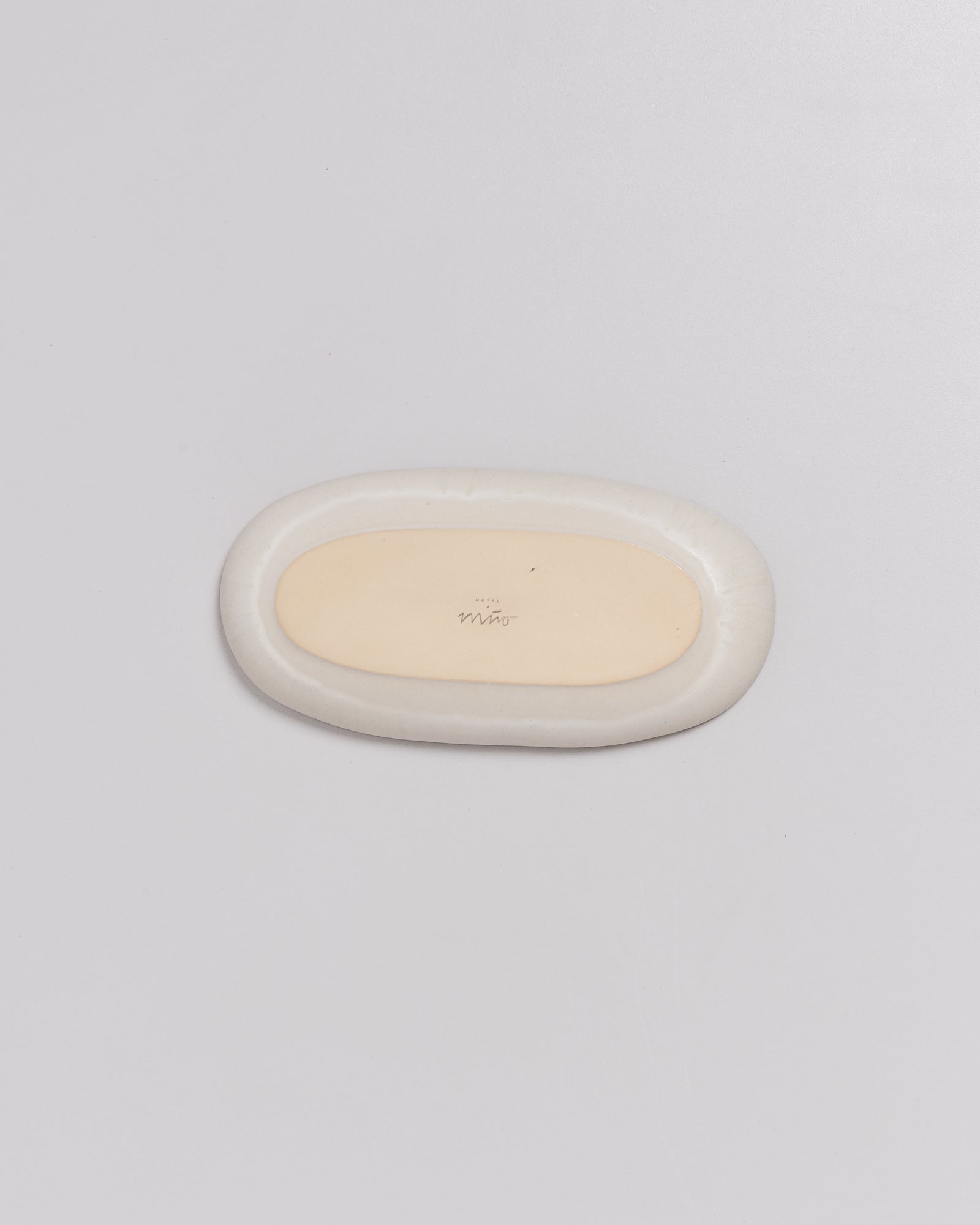 Ovale, zweifarbige Seifenschale auf weißem Hintergrund.