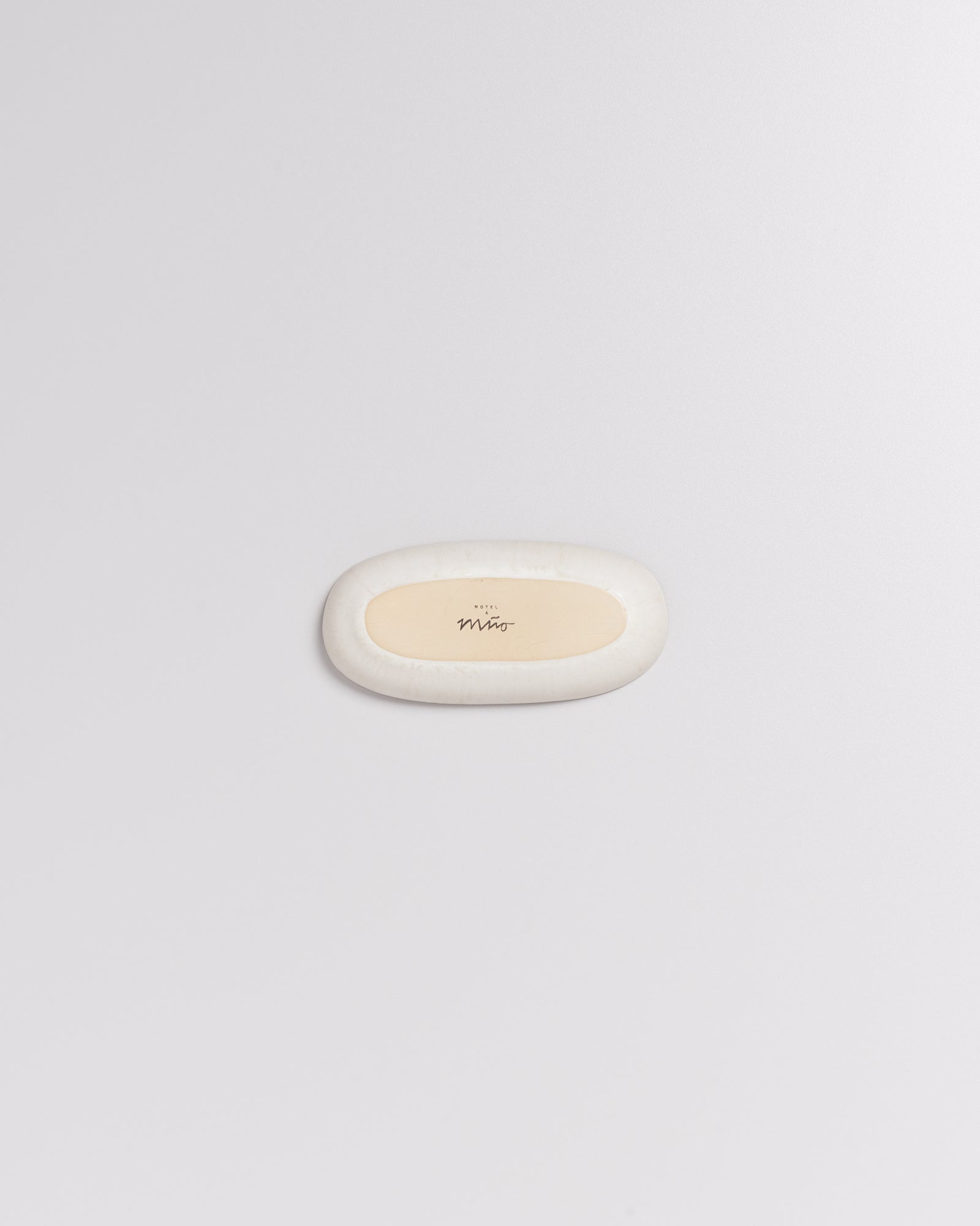 Ein ovaler, weißer Radiergummi mit einem beigen Zentrum und dem Wort "Miro" in der Mitte, auf weißem Hintergrund.