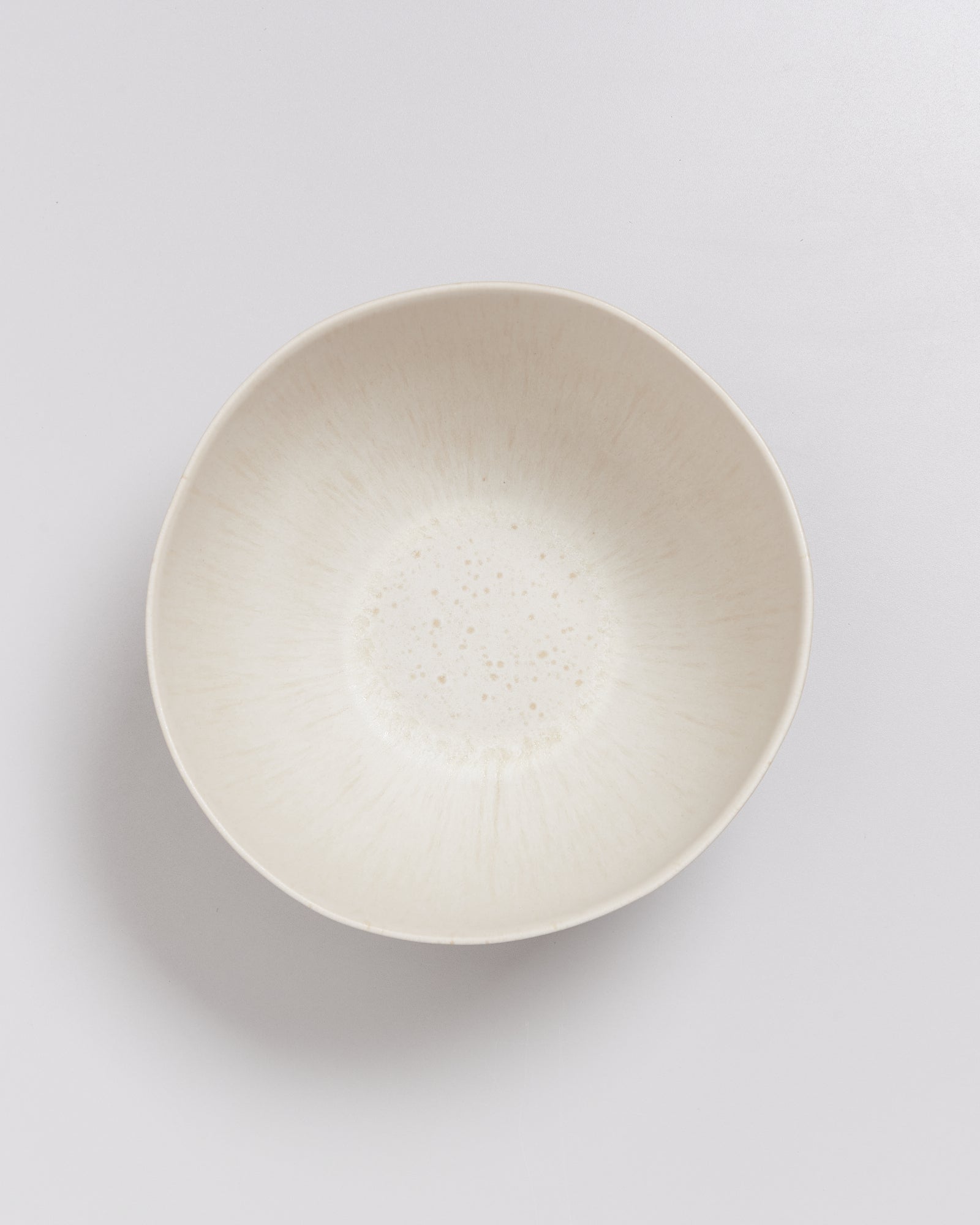 Eine weiße, leicht strukturierte Schale auf einem weißen Hintergrund.