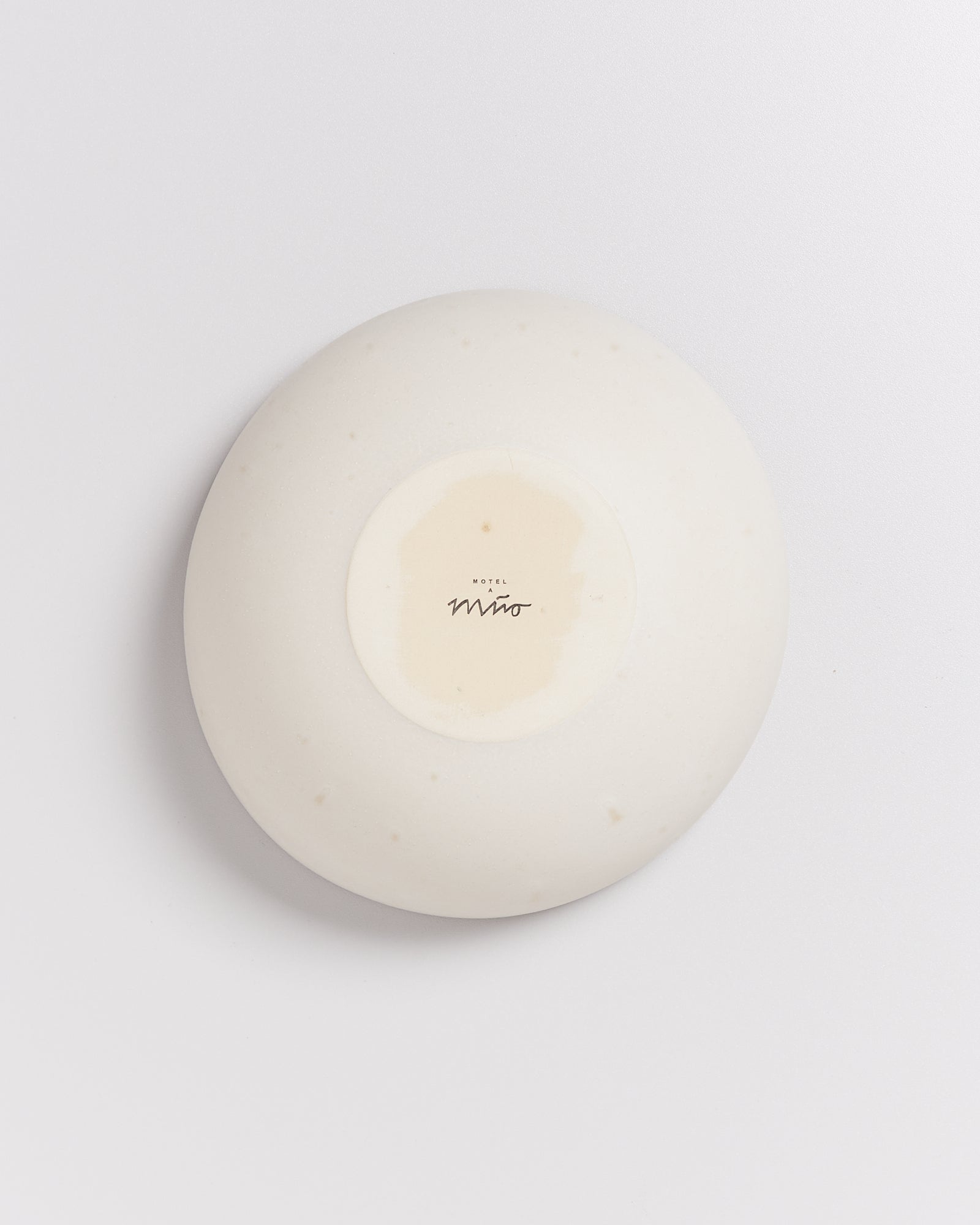 Weiße Porzellanschale mit glattem Design und der Aufschrift "Hotel Miro" auf der Unterseite.