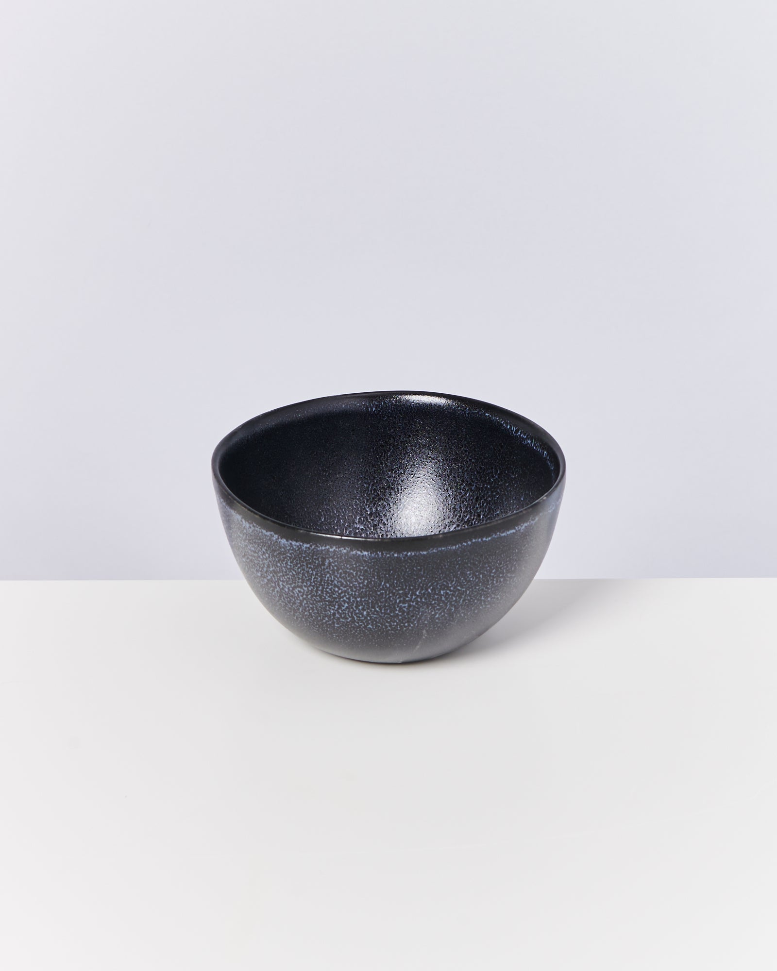 Schwarze, leicht glänzende Schüssel auf weißem Hintergrund.