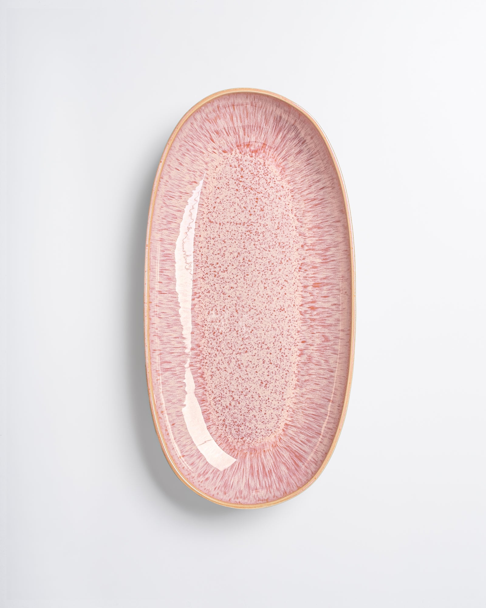 Ovaler Teller mit rosa-weißem Muster auf weißem Hintergrund.