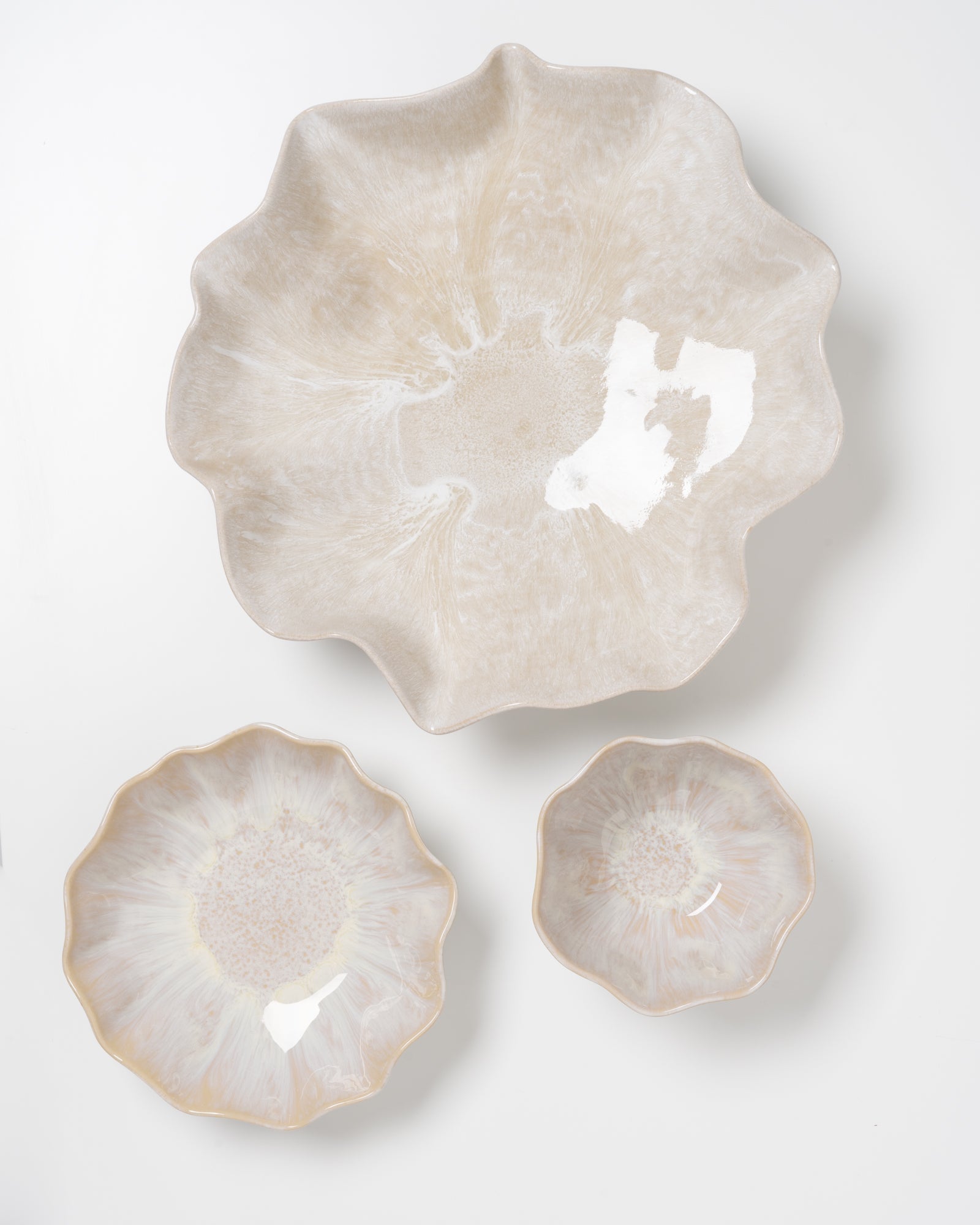 Drei beiger Keramikteller in Blumenform auf einem weißen Hintergrund.