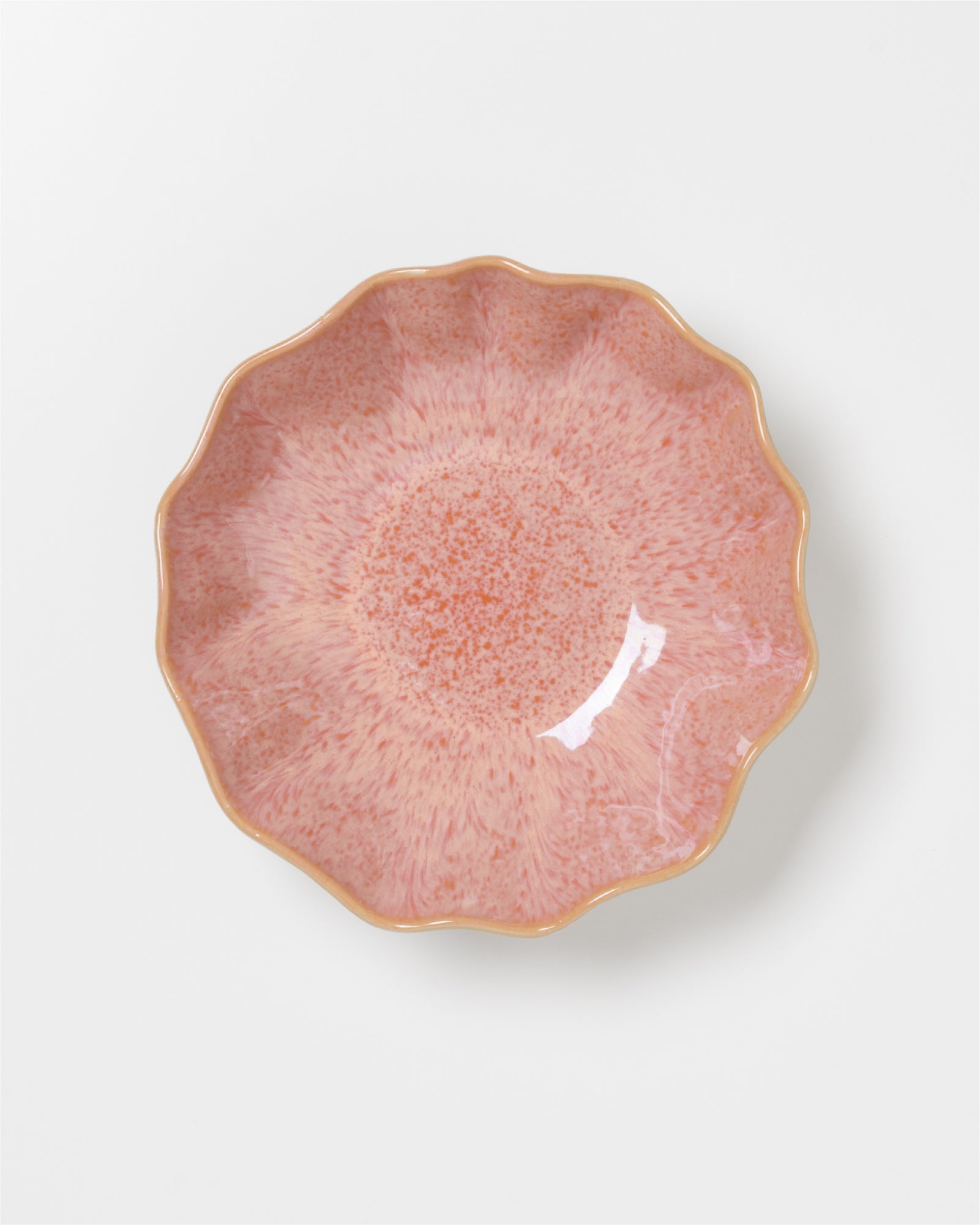 Rosa Schale mit welligem Rand und gesprenkeltem Muster auf weißem Hintergrund.