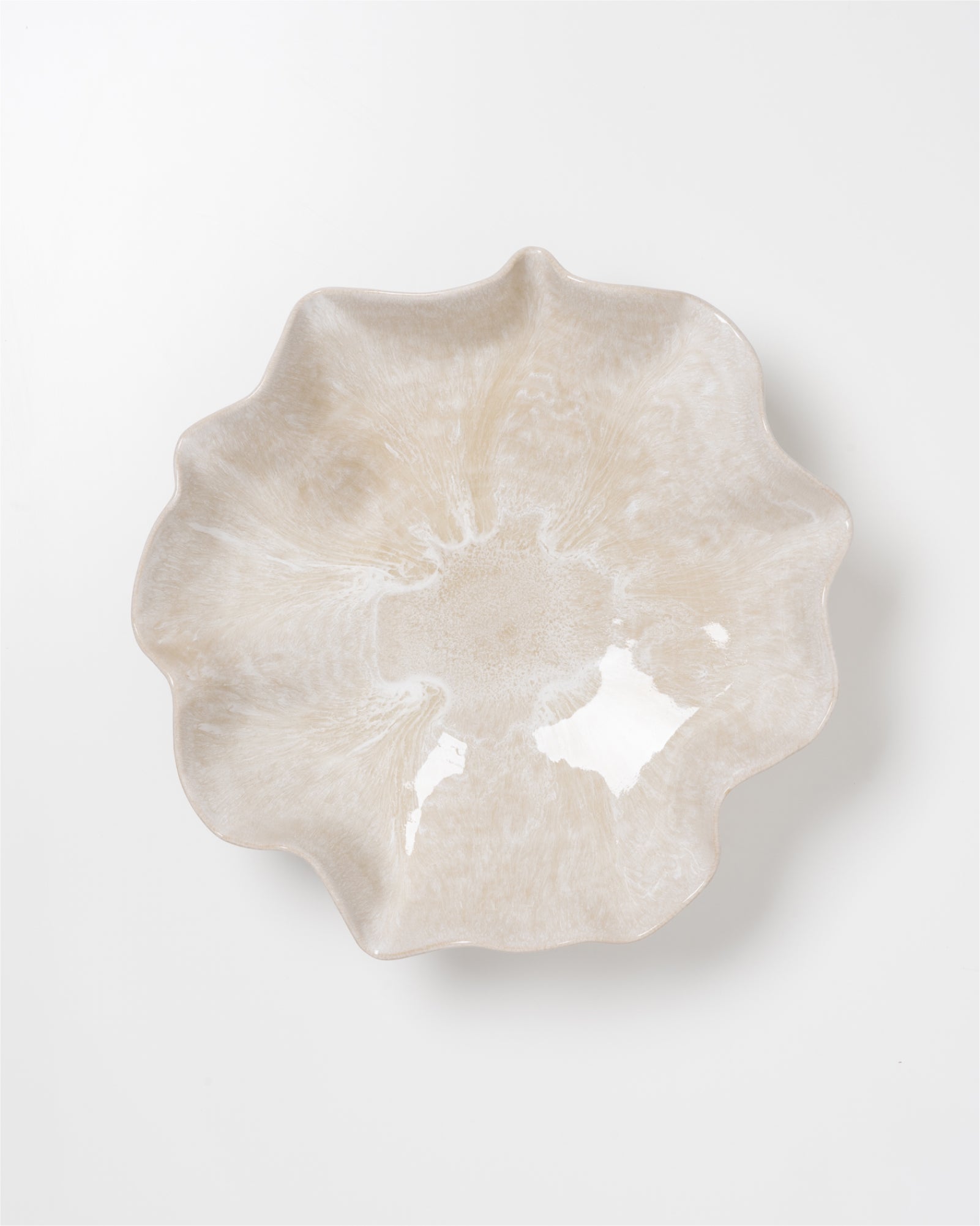 Beige, wellenförmige Keramikschale mit glänzender Oberfläche auf weißem Hintergrund.