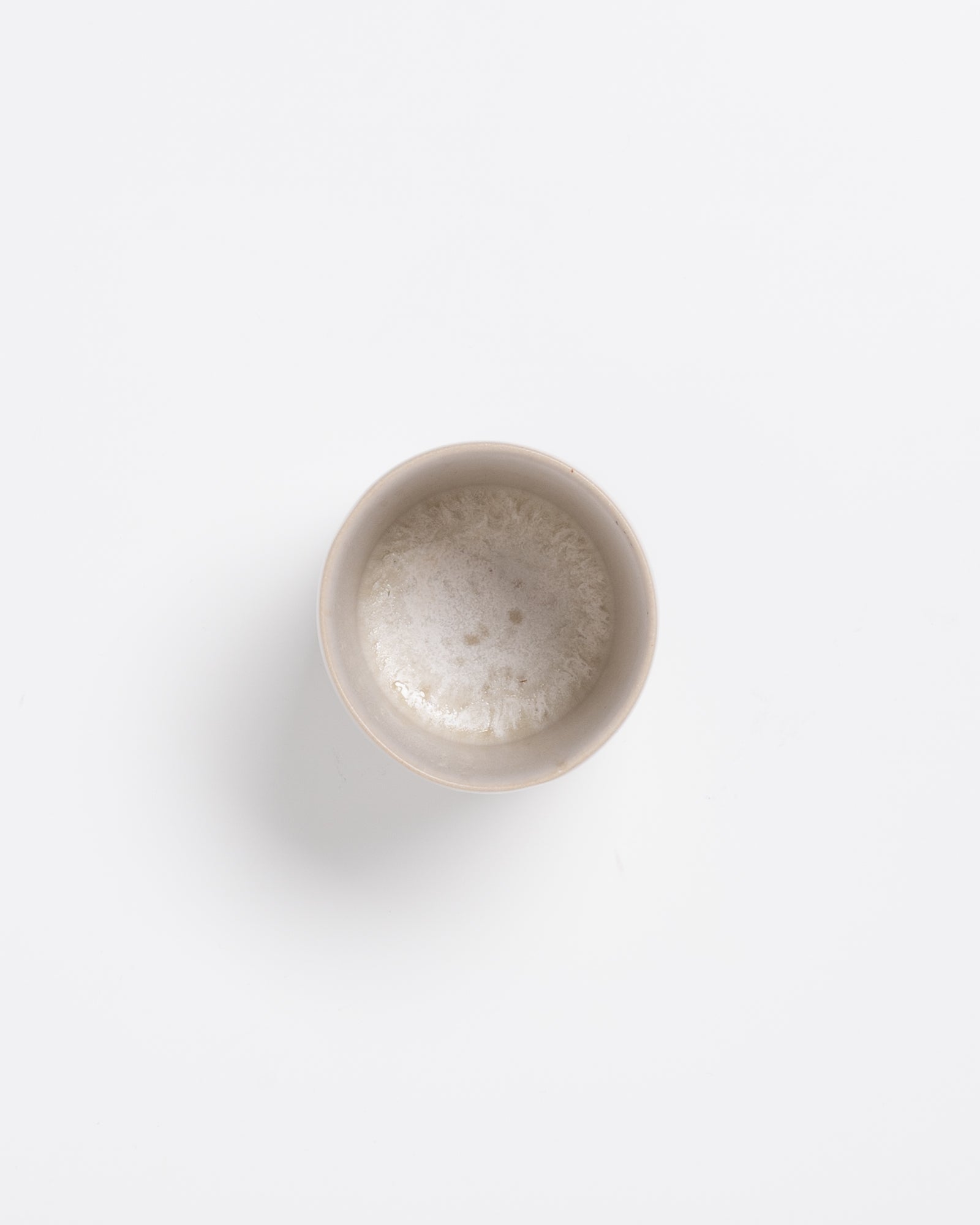 Tasse mit Schaum gefüllt, auf weißem Hintergrund.