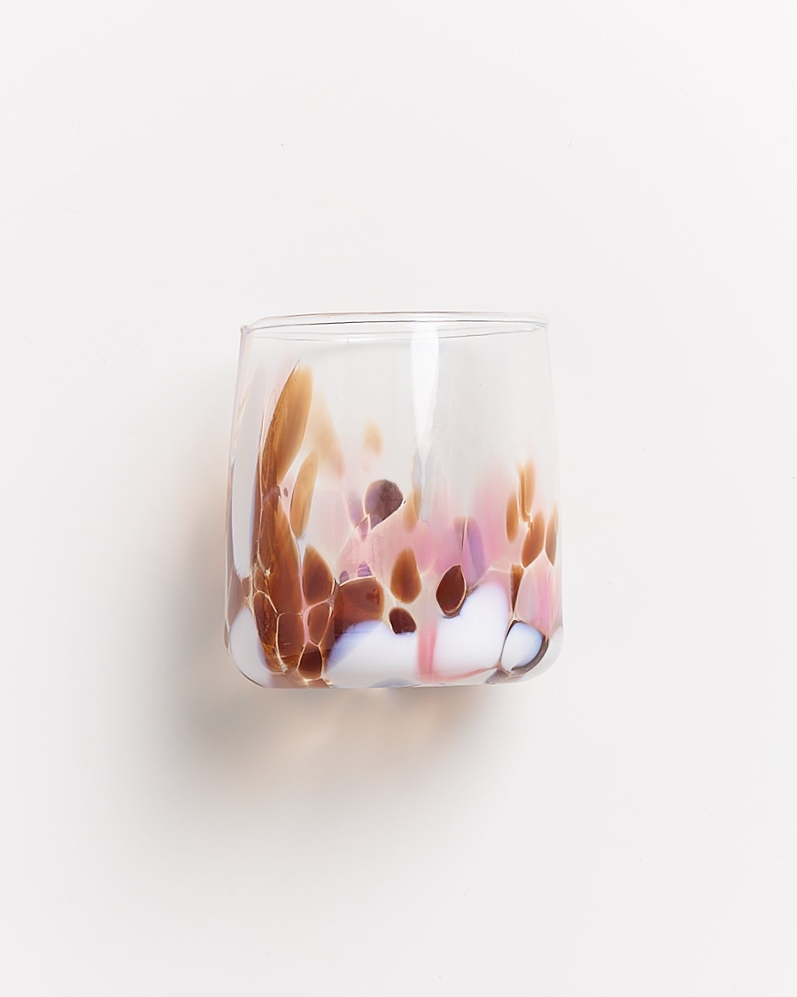 Ein Glas mit buntem, marmoriertem Muster in Braun-, Rosa- und Weißtönen auf weißem Hintergrund.