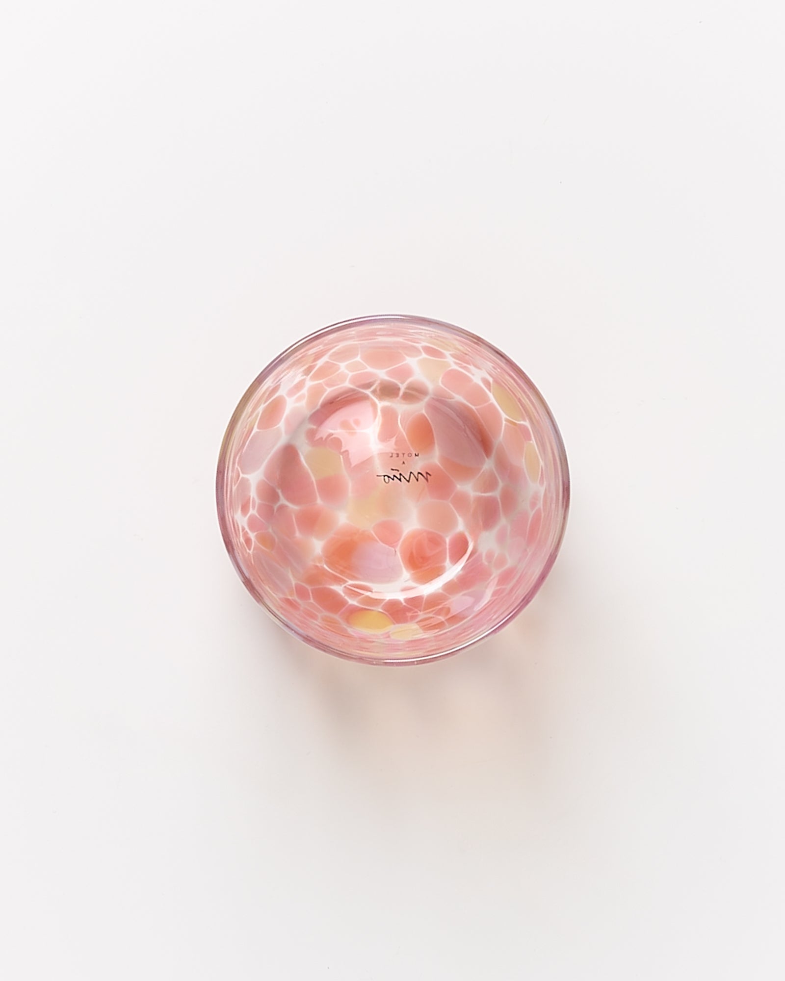 Runde Schale mit rosa- und gelb-gemustertem Design auf weißem Hintergrund.