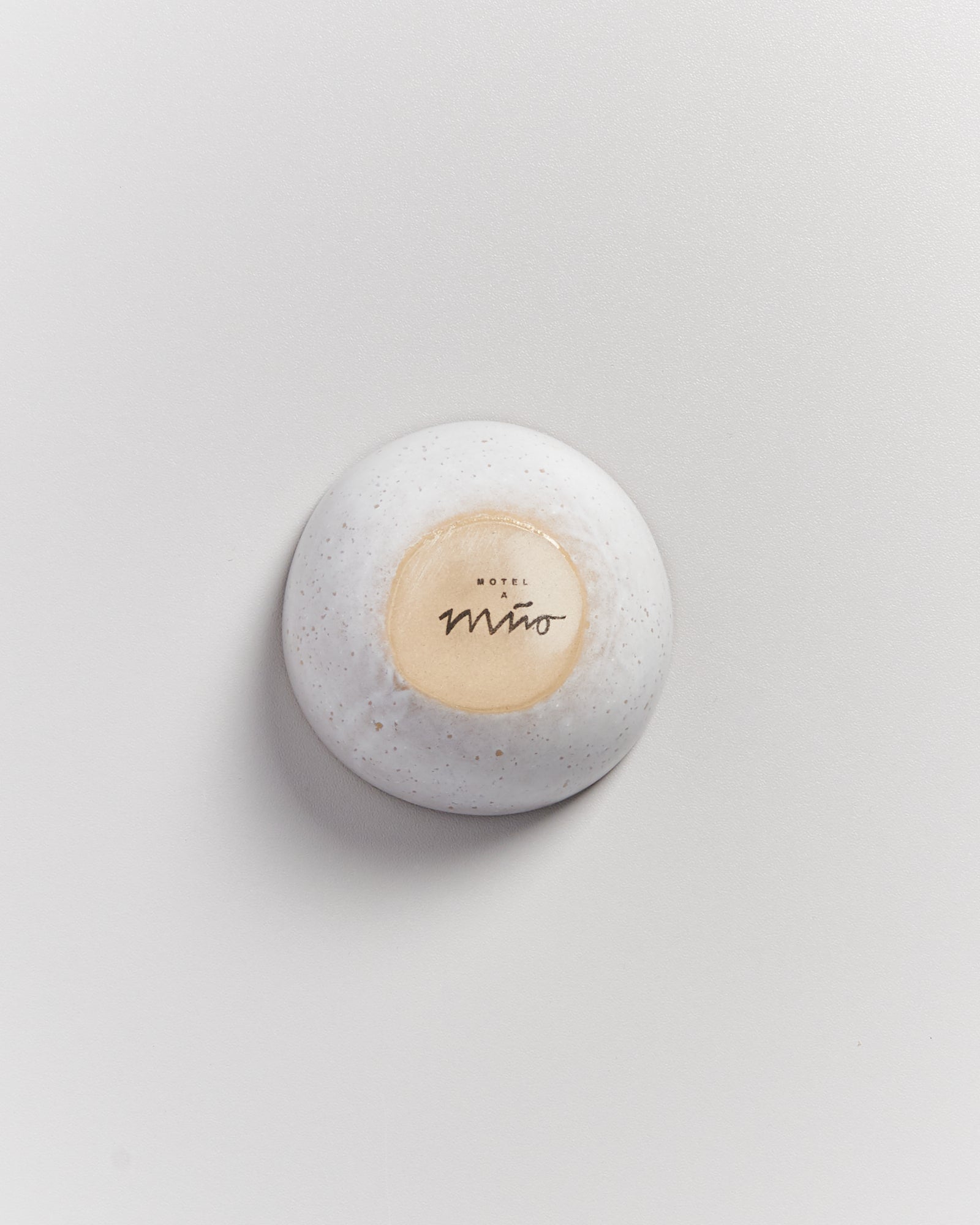 Runde, weiße Seife mit der Aufschrift "Motel a Mió" auf hellem Hintergrund.