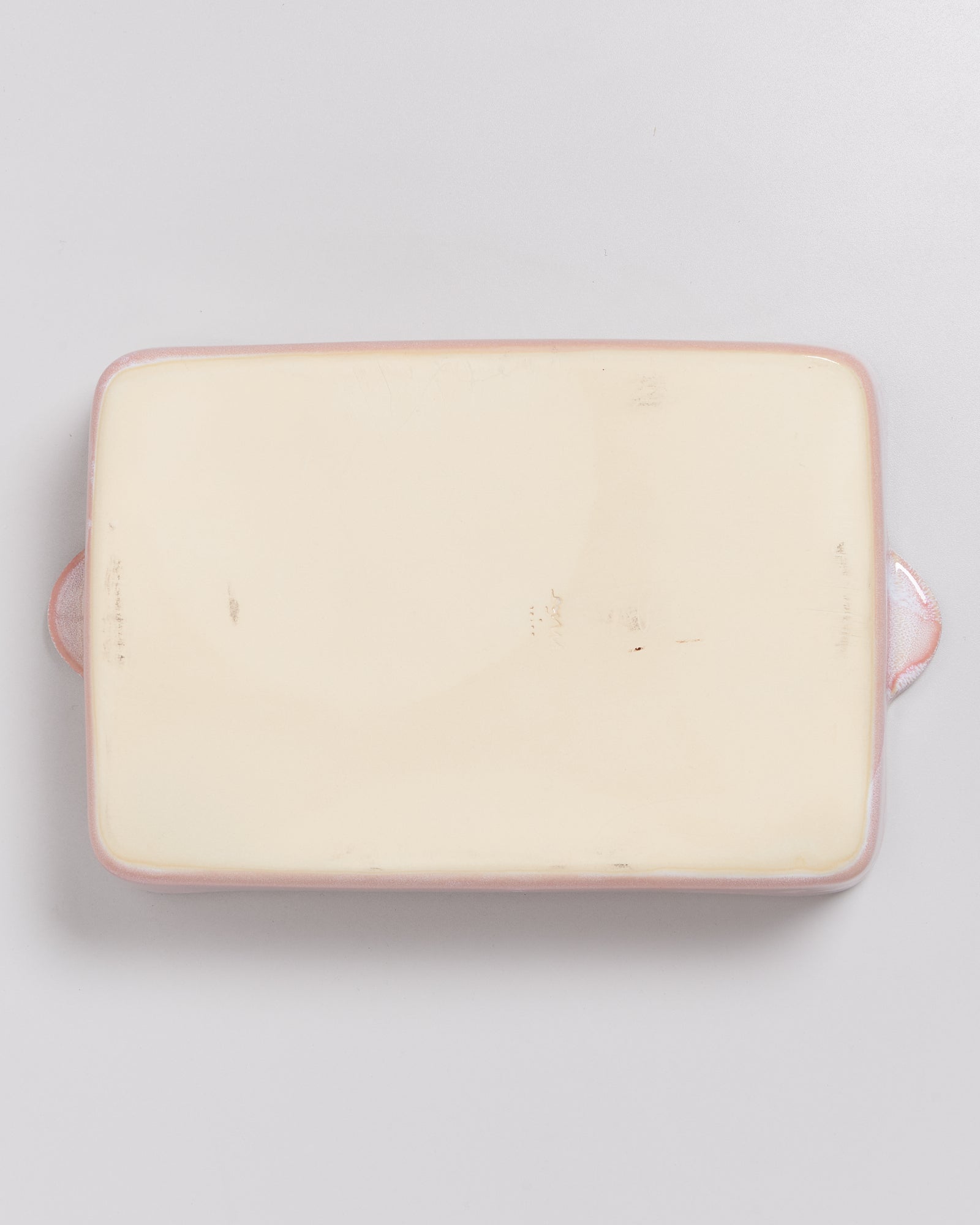 Rechteckige, cremefarbene Keramikauflaufform mit zwei seitlichen Griffen, von oben fotografiert.