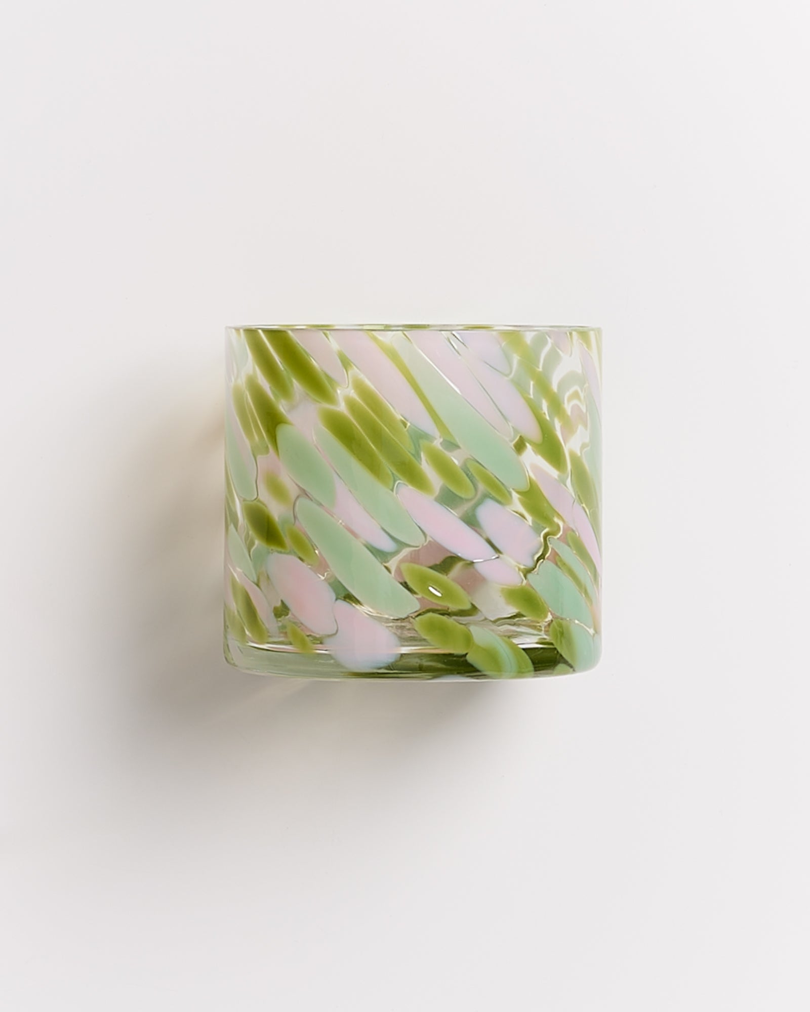 Grünes und rosa getupftes Glasgefäß vor weißem Hintergrund.