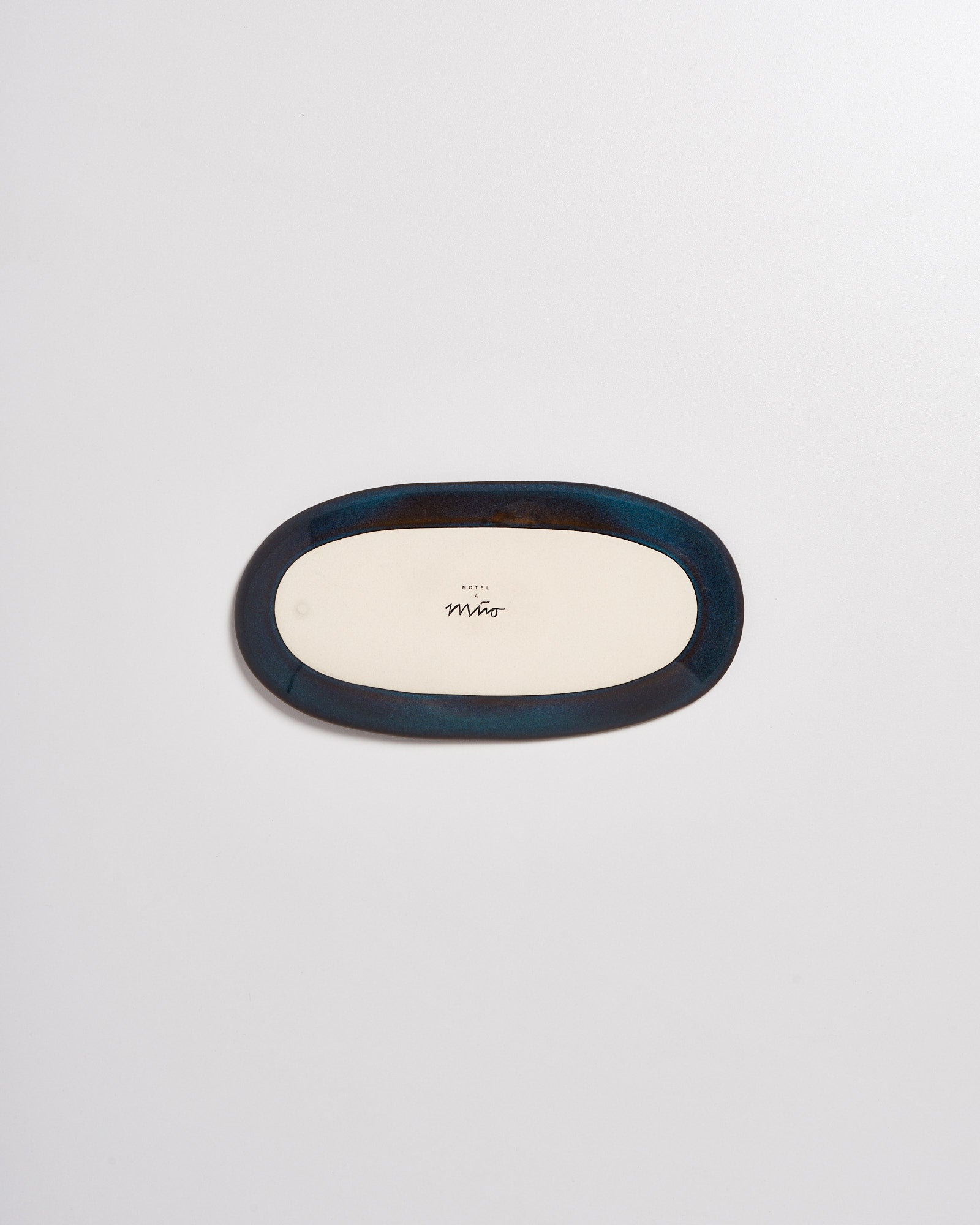 Ovaler Teller mit blauem Rand und der Aufschrift "Hotel Miro" auf hellem Hintergrund.